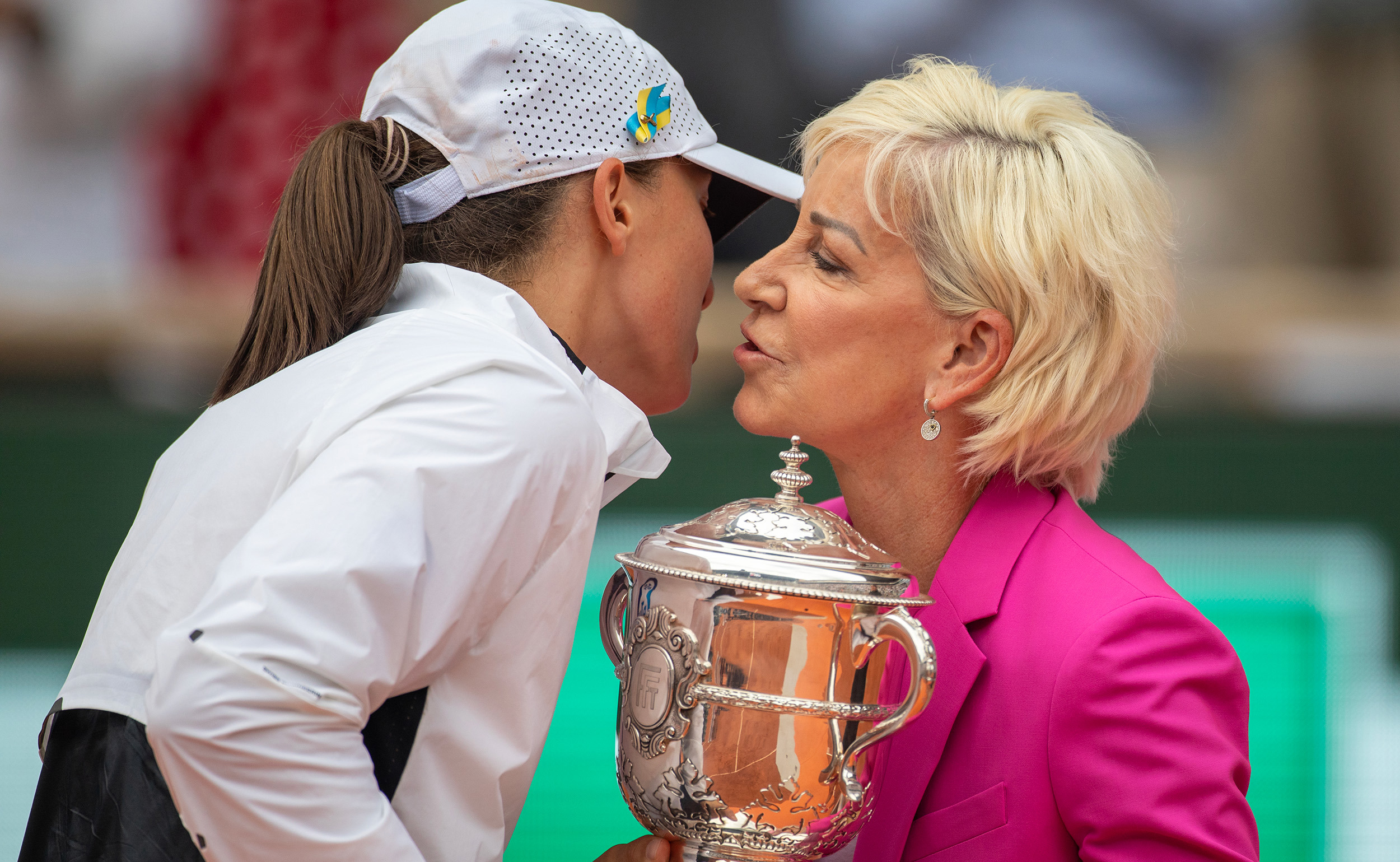 Iga Swiatek is presented her 2023 Roland-Garros trophy by Chris Evert.