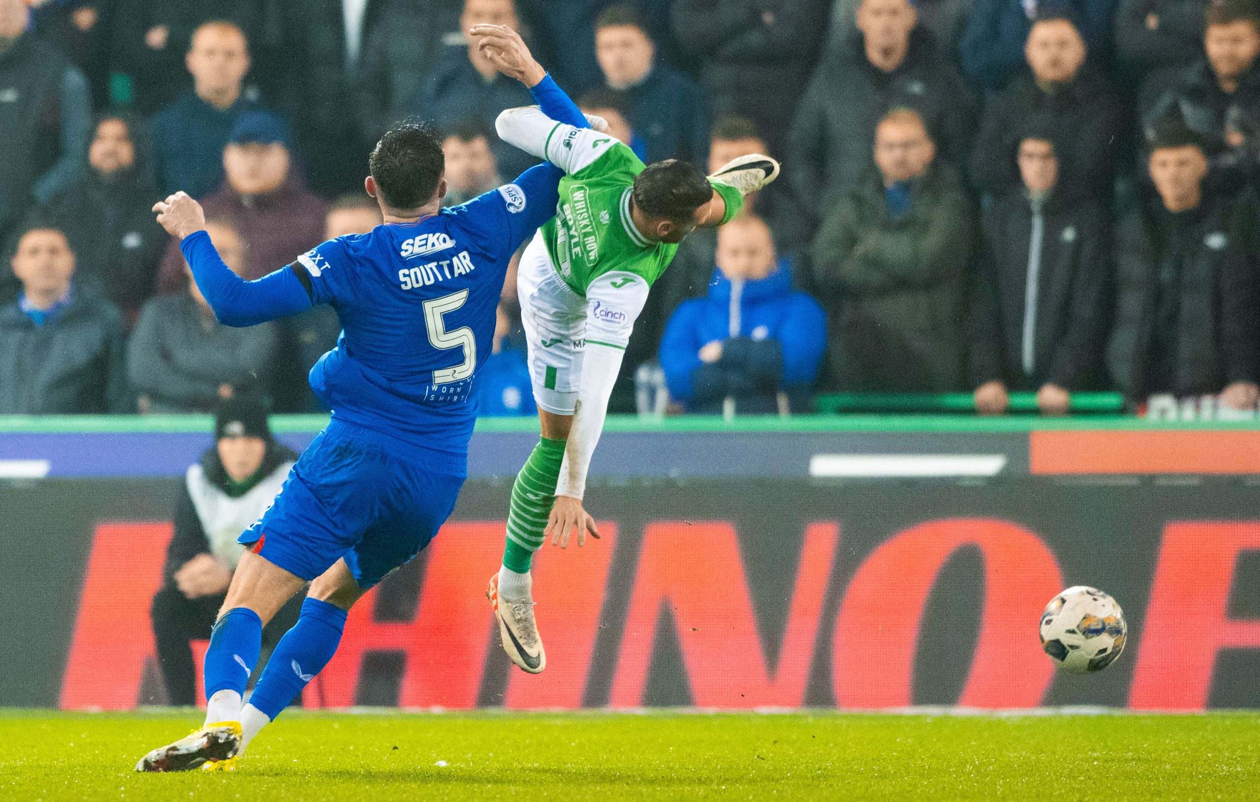 Hibernian's Martin Boyle collides with Rangers' John Souttar before going down injured.