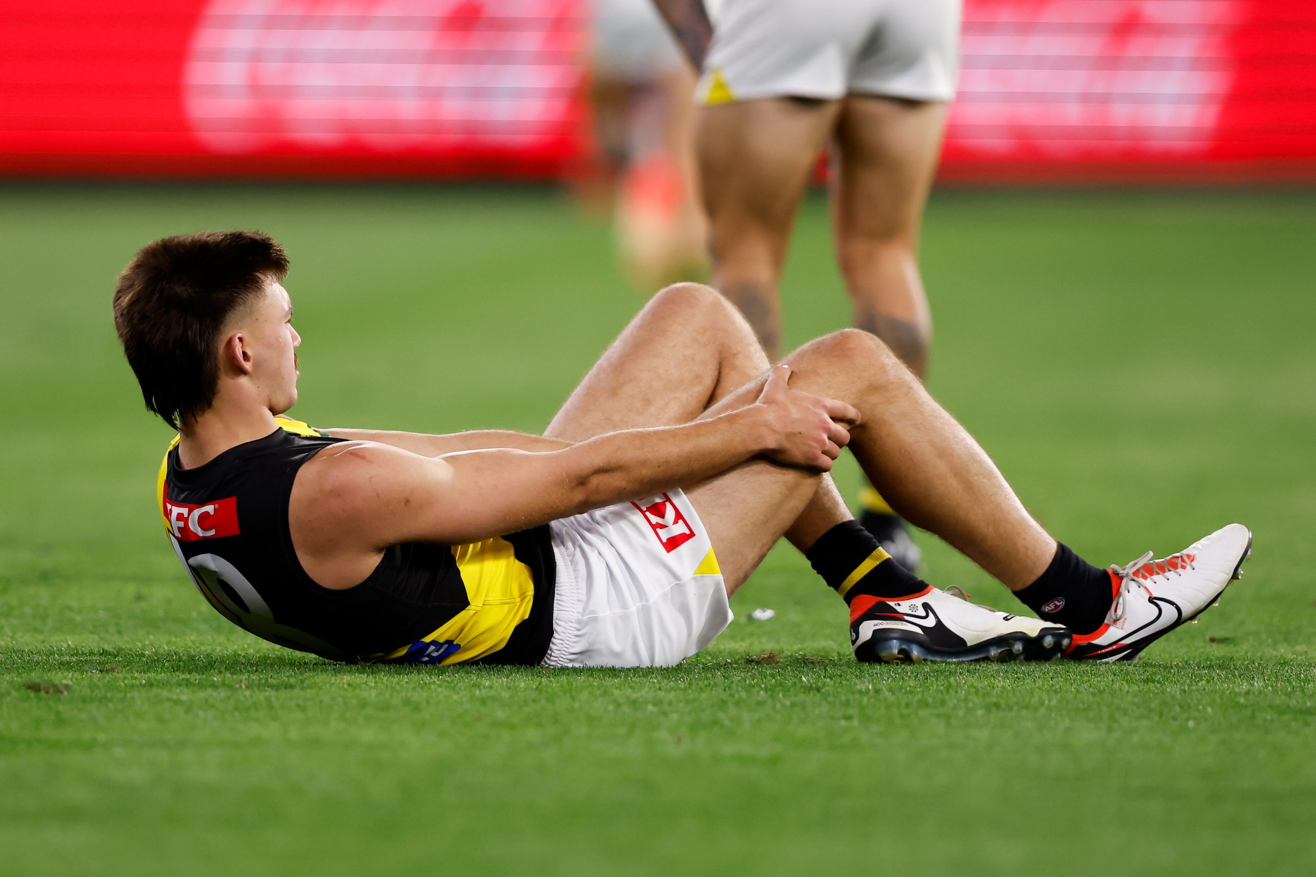 Josh Gibcus of the Tigers is seen with an injured knee during the 2024 AFL Round 01 match between the Carlton Blues and the Richmond Tigers at the Melbourne Cricket Ground on March 14, 2024 in Melbourne, Australia. (Photo by Dylan Burns/AFL Photos via Getty Images)