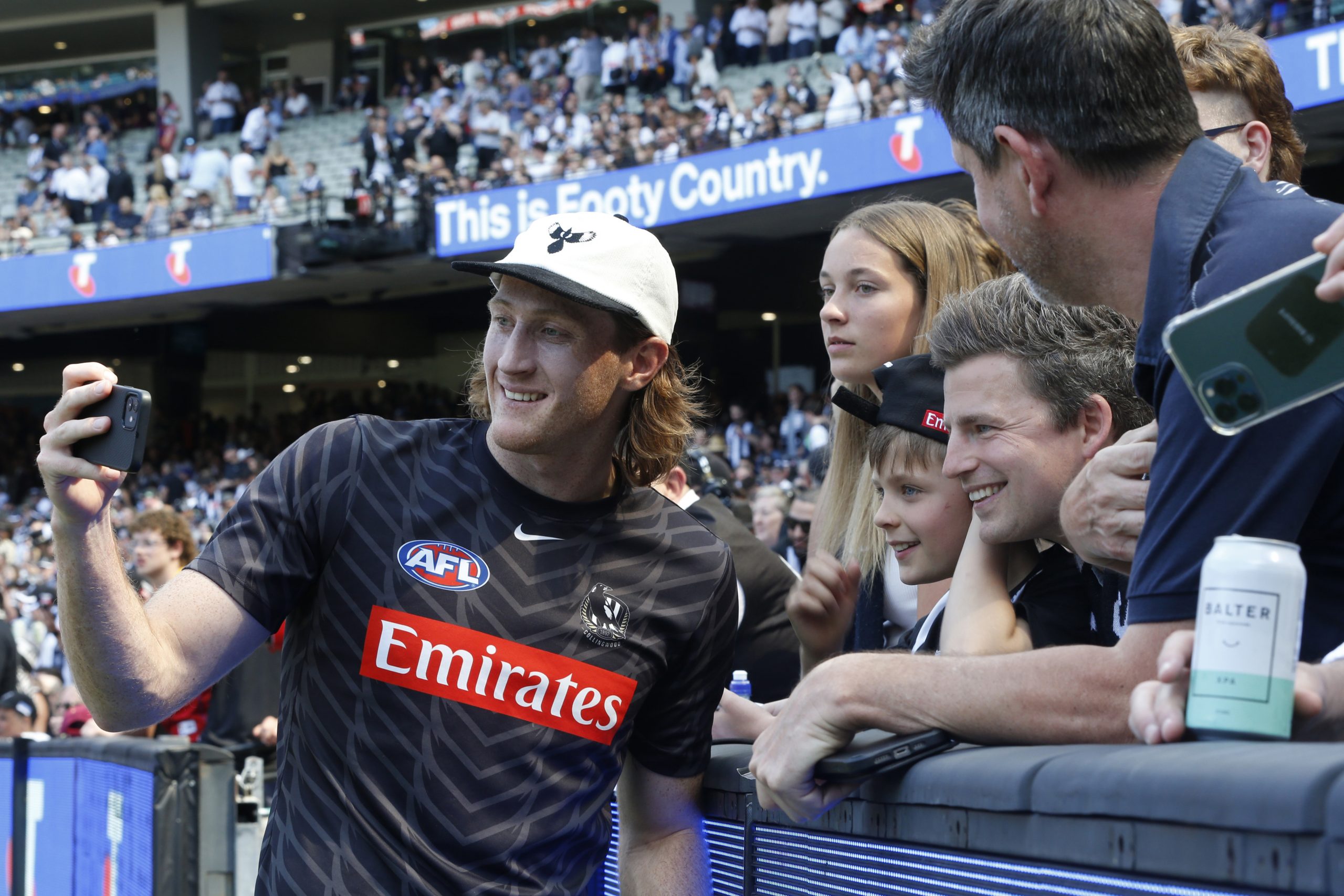 Magpies defender Nathan Murphy poses for selfies with fans.