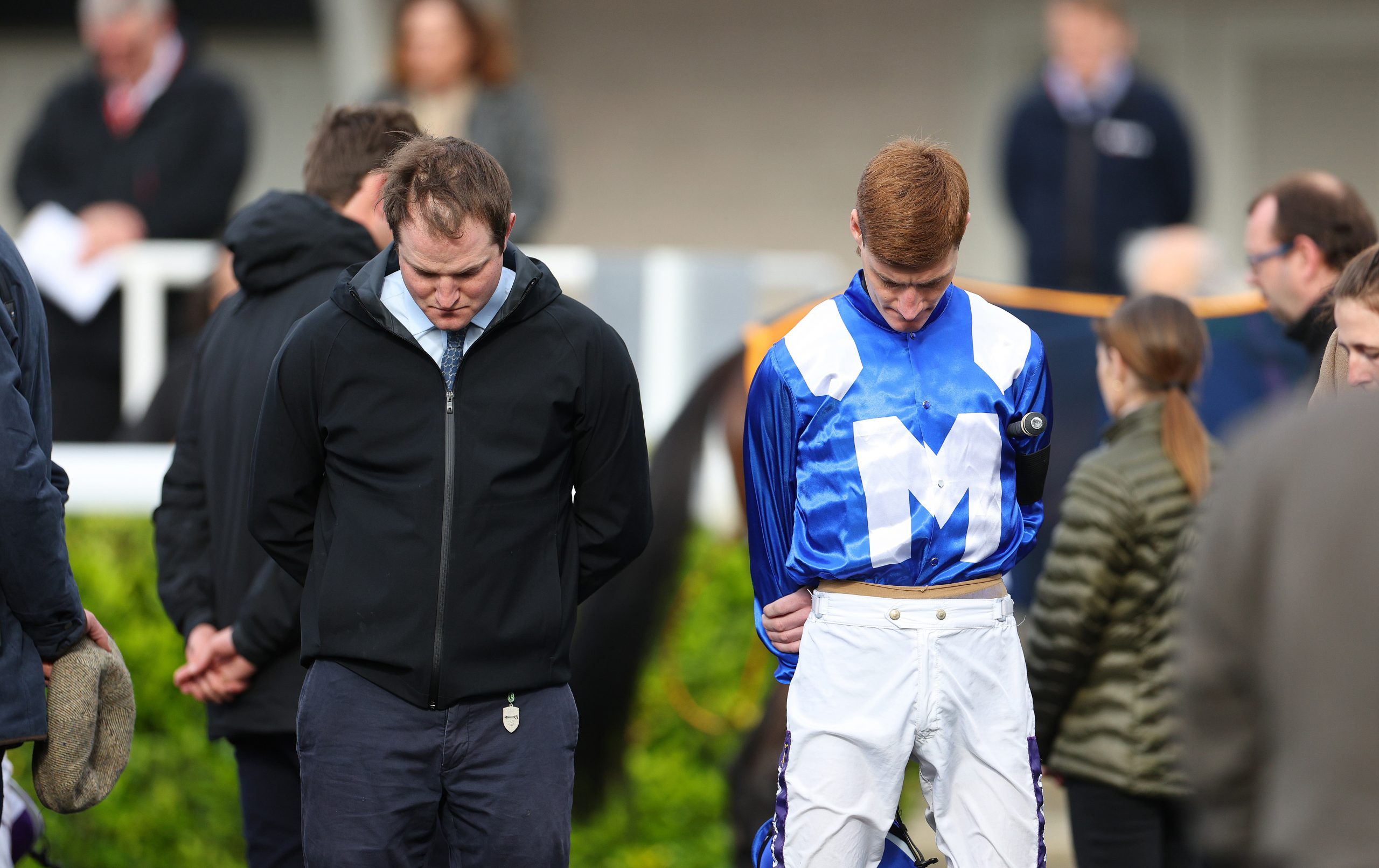 Jockey Daniel Muscutt observes a minute's silence as a mark of respect to Stefano Cherchi at Kempton Park in England.