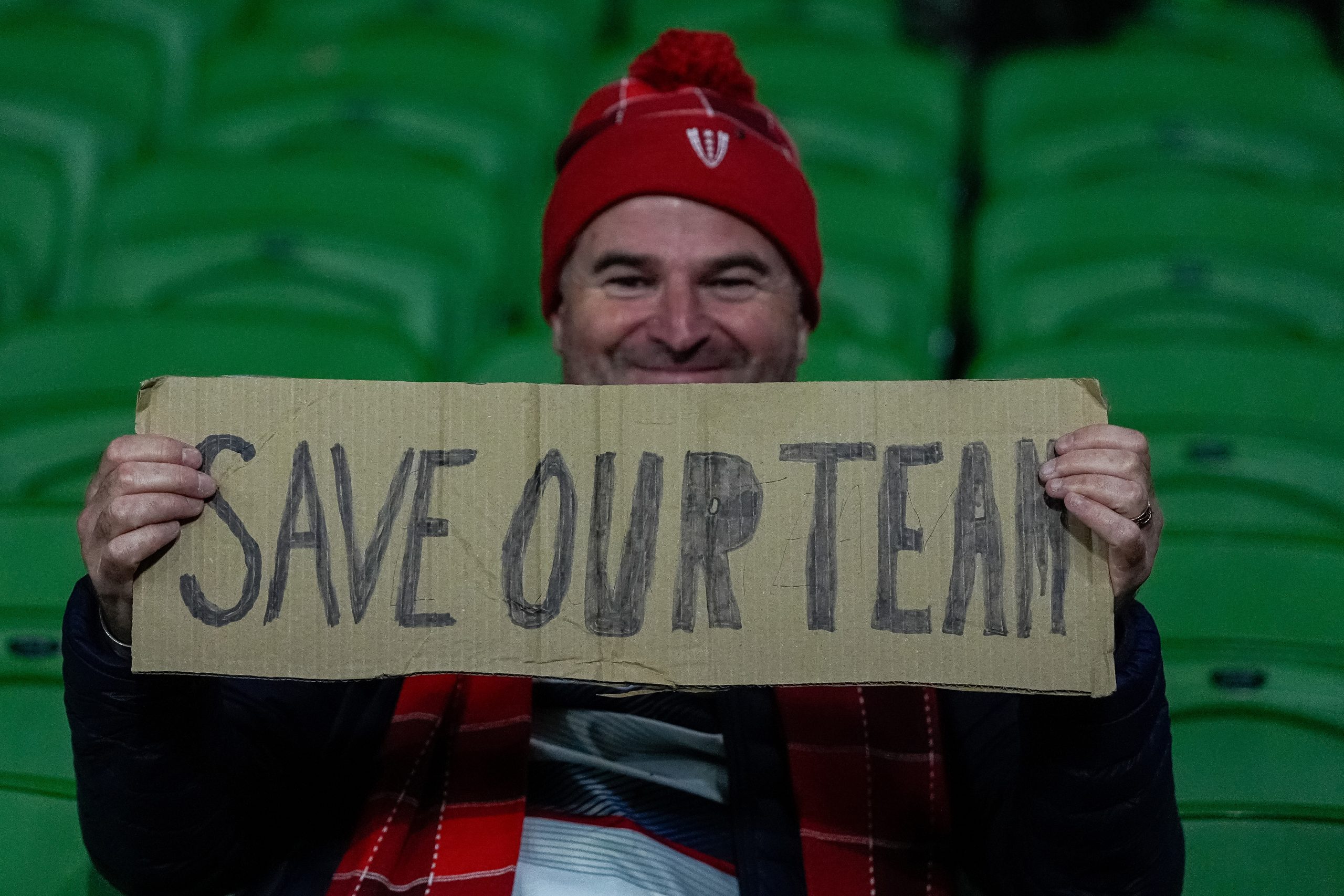 A Melbourne Rebels supporter holds up a sign reading 'Save our team'.