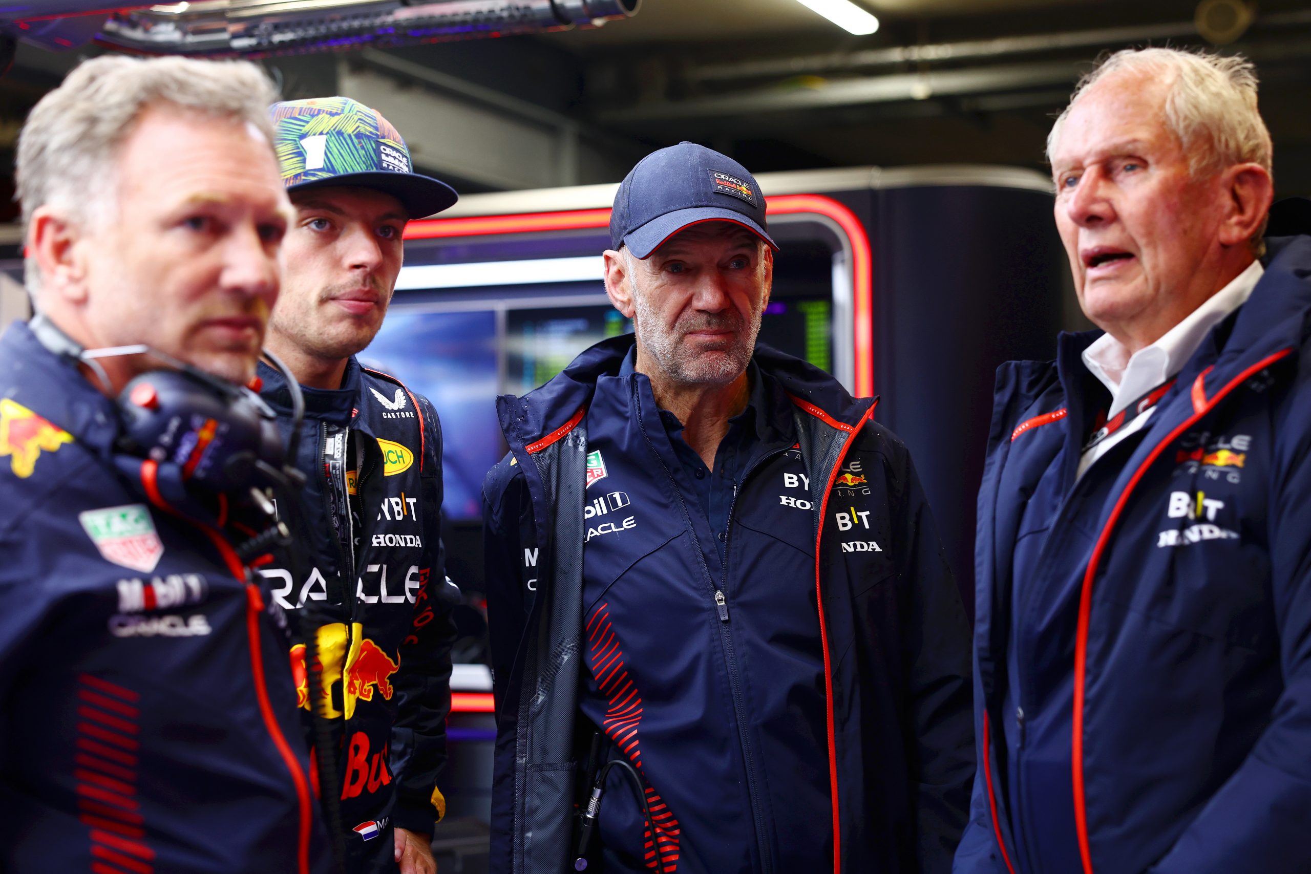 Red Bull Racing team principal Christian Horner, driver Max Verstappen, chief technical officer Adrian Newey and team consultant Helmut Marko look on in the garage.