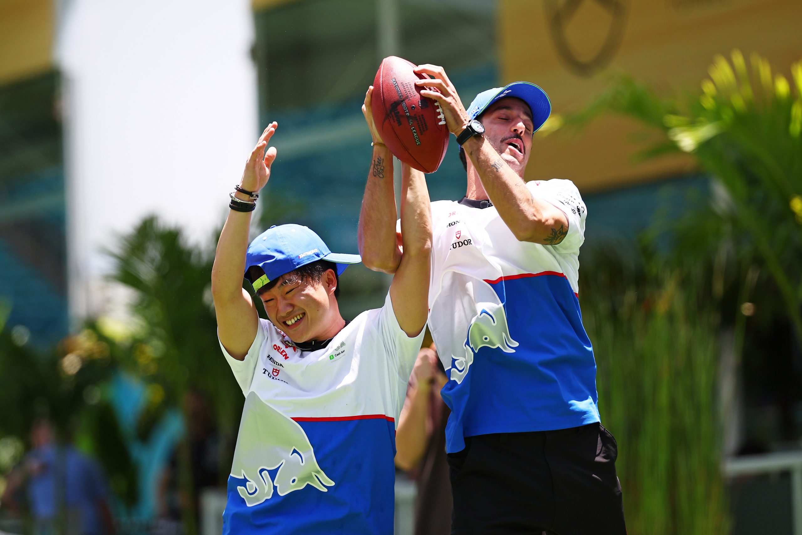 Daniel Ricciardo of Australia and Visa Cash App RB and Yuki Tsunoda of Japan and Visa Cash App RB compete for a catch as the play football in the Paddock during previews ahead of the F1 Grand Prix of Miami at Miami International Autodrome on May 02, 2024 in Miami, Florida. (Photo by Jared C. Tilton - Formula 1/Formula 1 via Getty Images)