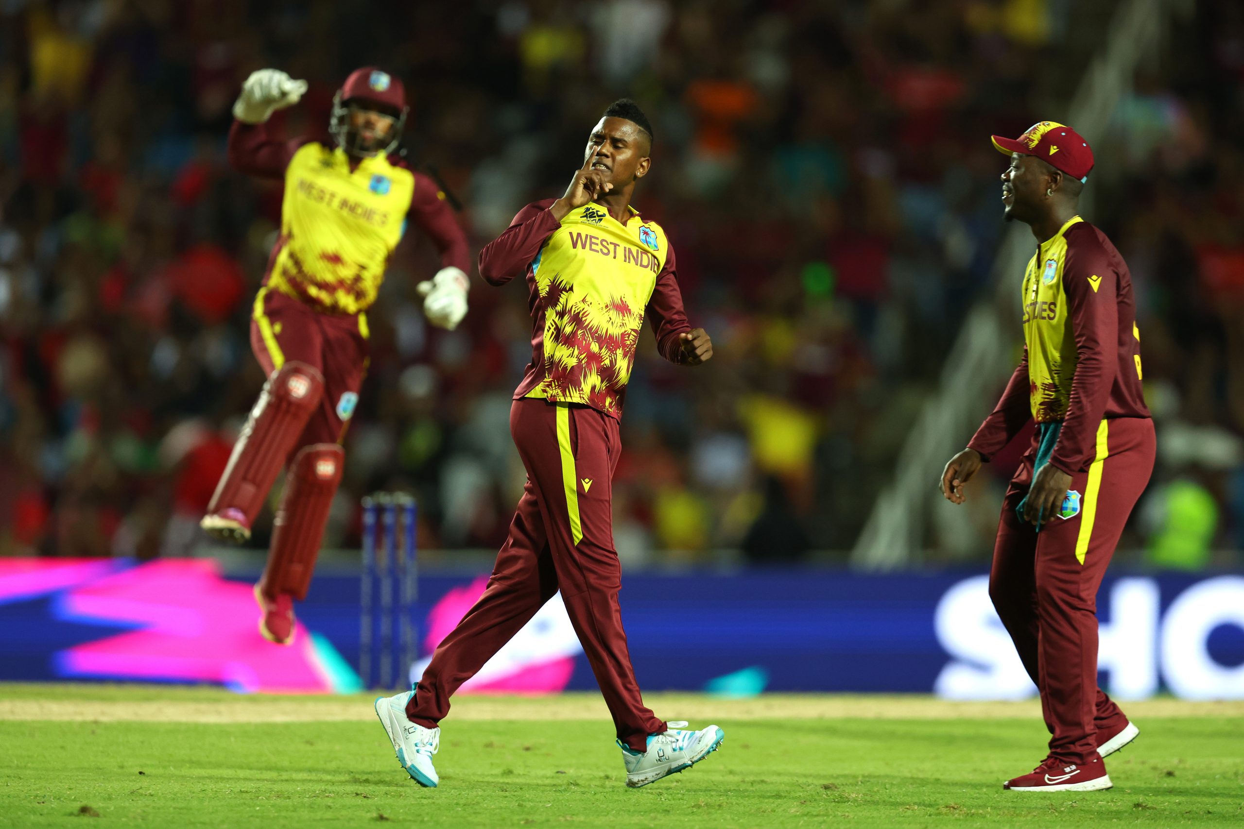 Akeal Hosein and Nicholas Pooran of the West Indies celebrate the wicket of Devon Conway of New Zealand.