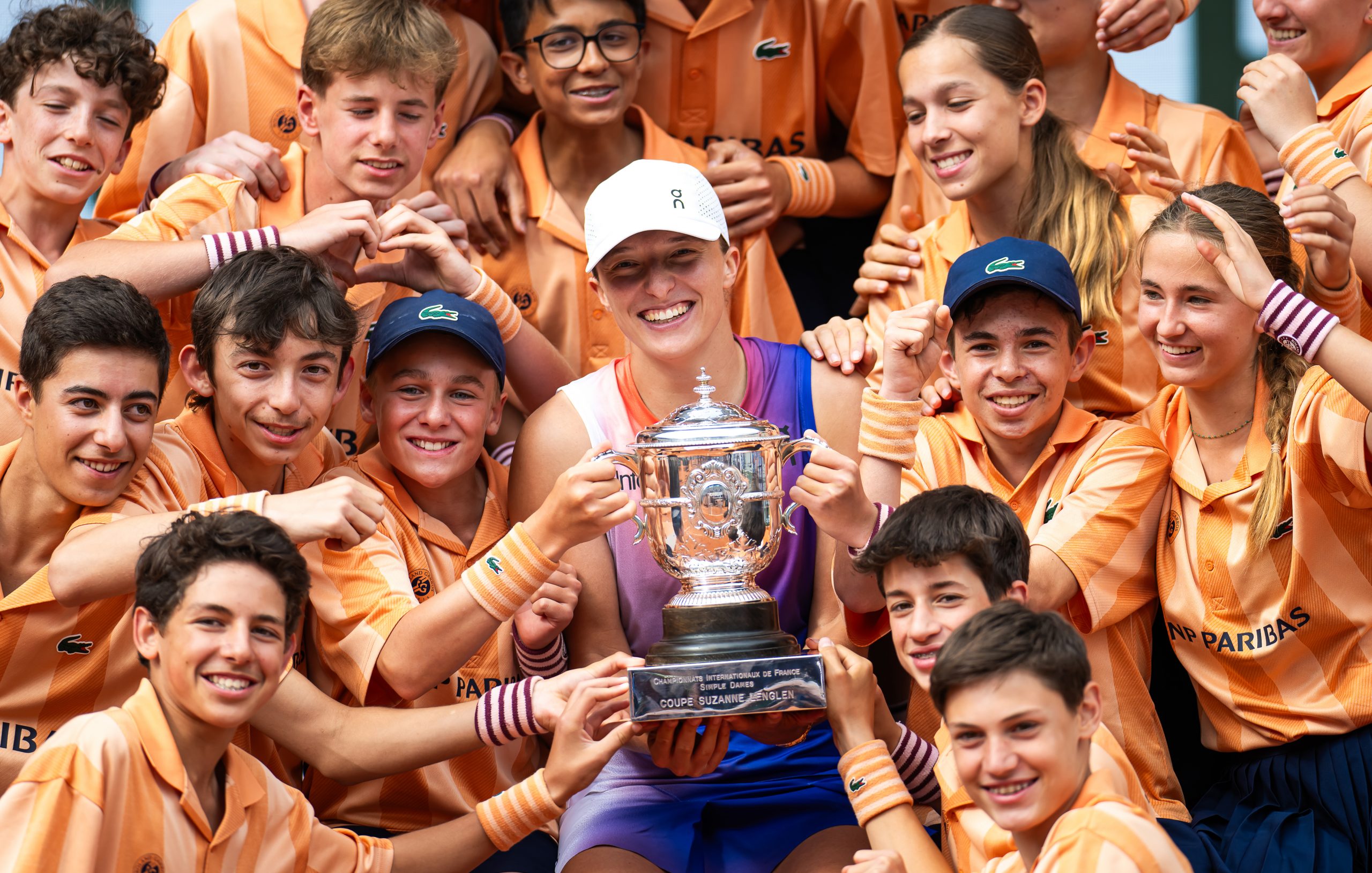 Iga Swiatek of Poland poses among ball kids with the champions trophy after defeating Jasmine Paolini of Italy in the womens singles final on Day 14 of the French Open at Roland Garros on June 08, 2024 in Paris, France (Photo by Robert Prange/Getty Images)