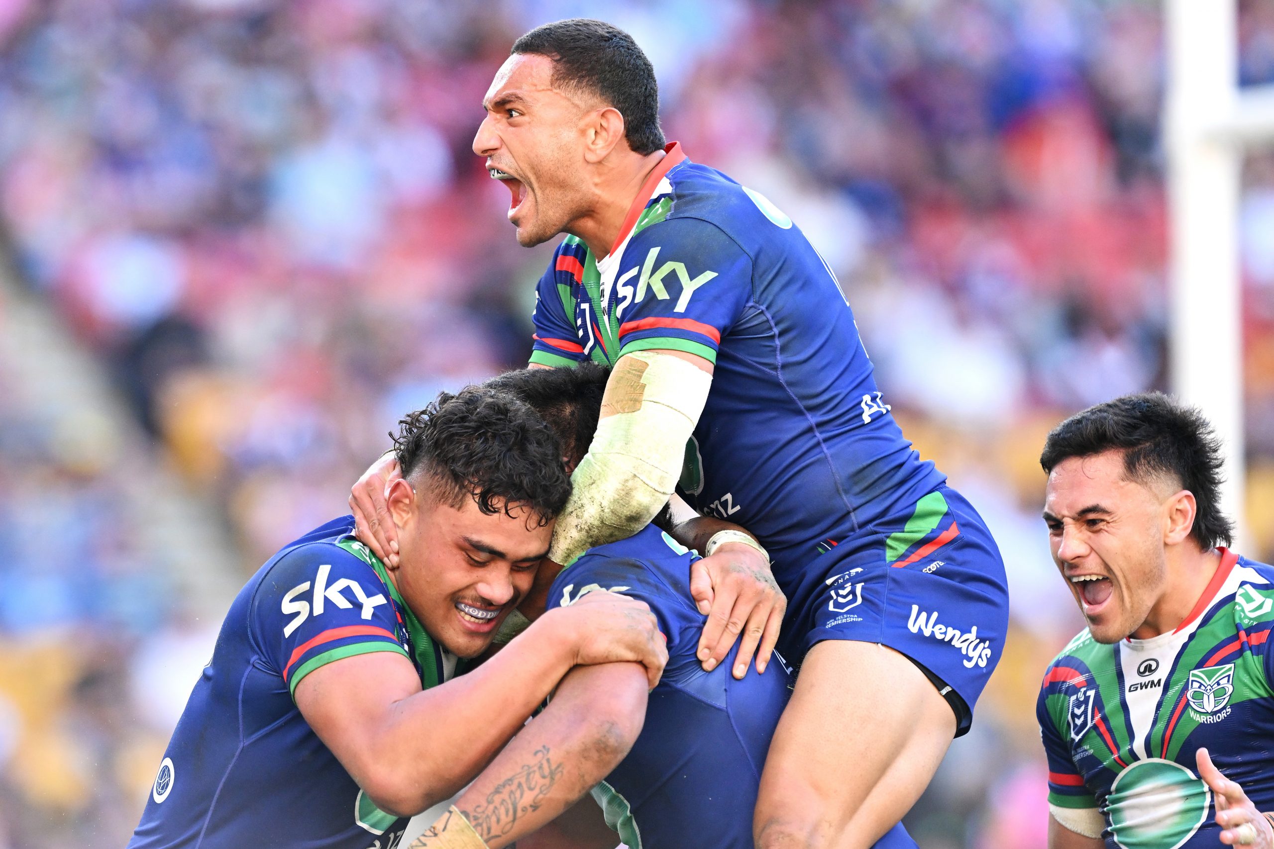 Jacob Laban, Marcelo Montoya and Paul Roache of the Warriors celebrate with Adam Pompey of the Warriors after he scored a try against the Panthers.