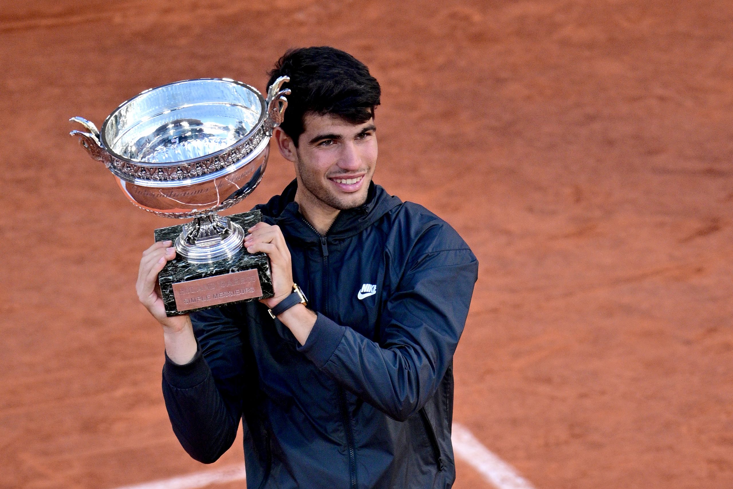 Carlos Alcaraz of Spain celebrates with the winners trophy after victory in the Men's Singles Final match between Alexander Zverev of Germany and Carlos Alcaraz of Spain on Day 15 of the 2024 French Open at Roland Garros on June 09, 2024 in Paris, France. (Photo by Lionel Hahn/Getty Images)