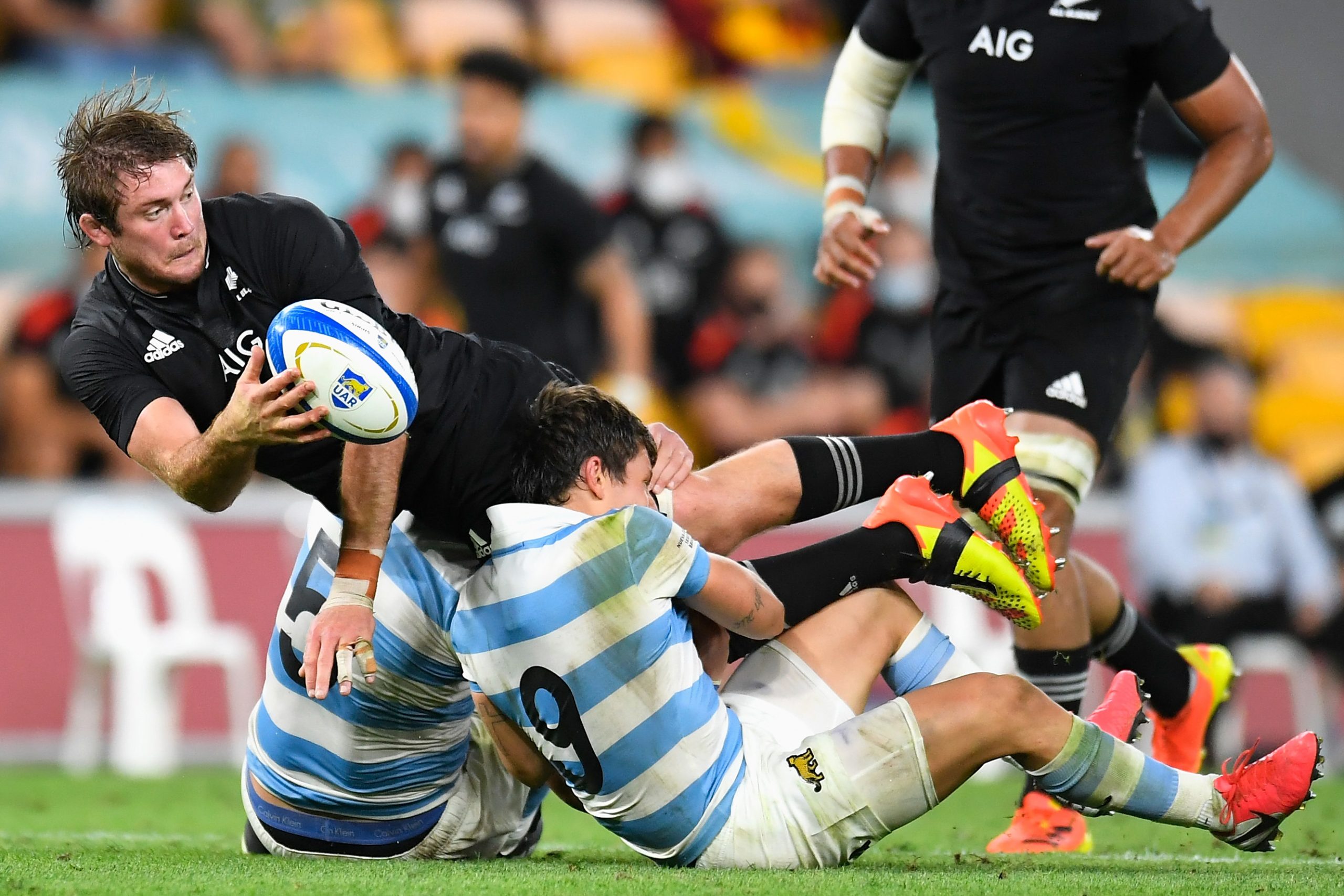 Ethan Blackadder of the All Blacks offloads the ball in a tackle.