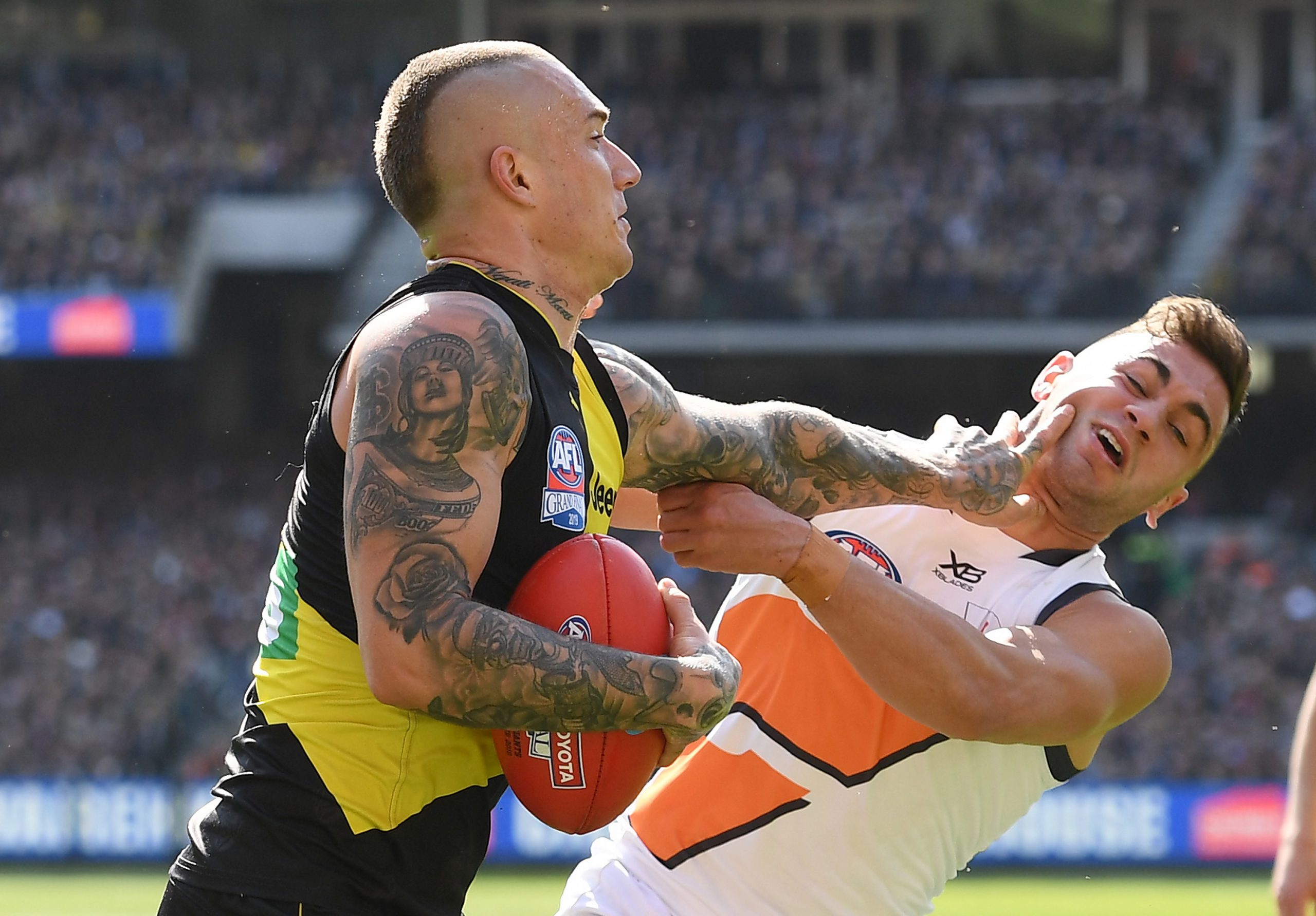 Dustin Martin of the Tigers fends off a tackle by Tim Taranto of the Giants during the 2019 AFL Grand Final match between the Richmond Tigers and the Greater Western Sydney Giants at Melbourne Cricket Ground on September 28, 2019 in Melbourne, Australia. (Photo by Quinn Rooney/Getty Images)