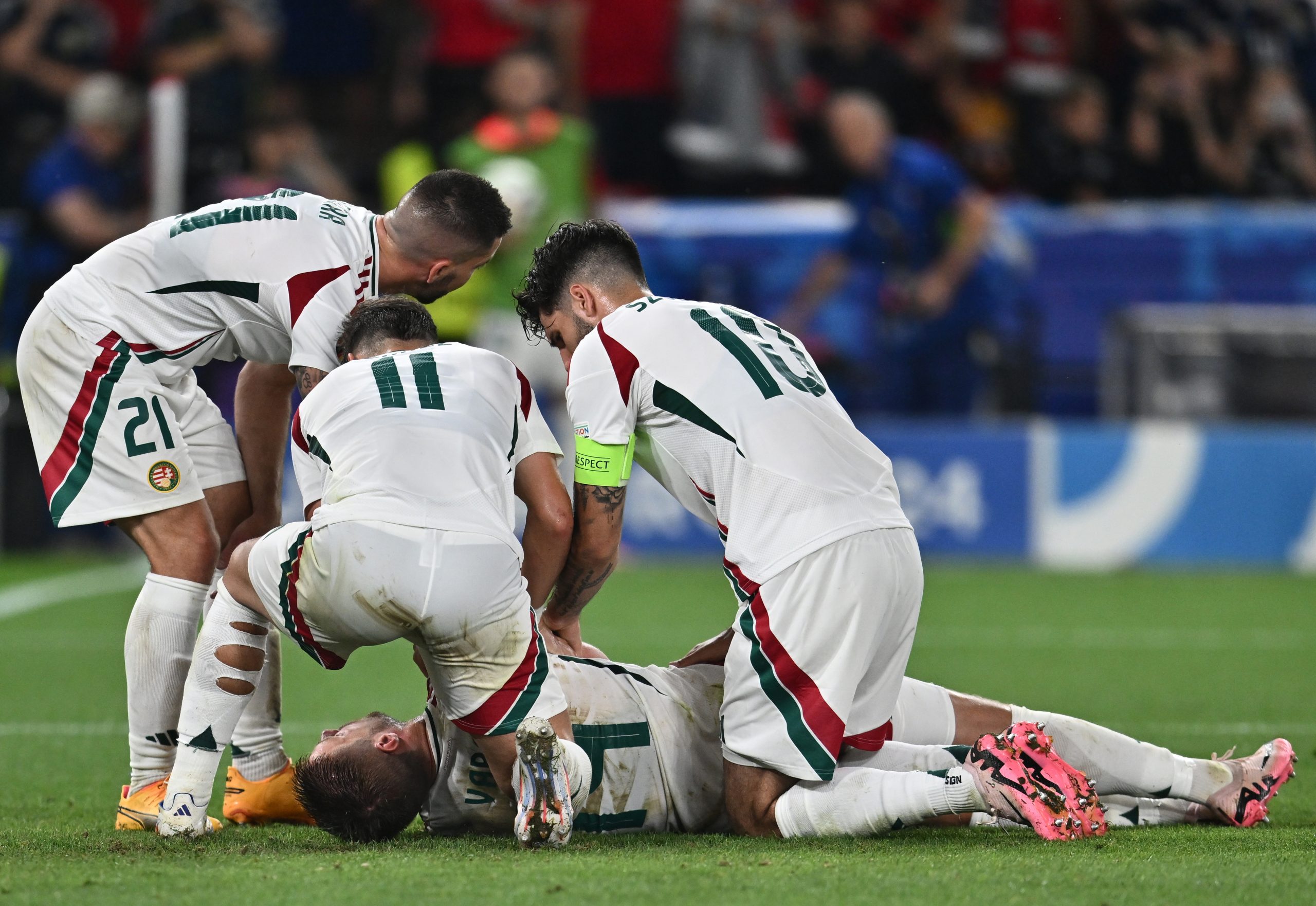 Barnabas Varga of Hungary lies on the ground and is assisted by teammates after a collision with goalkeeper Angus Gunn of Scotland.