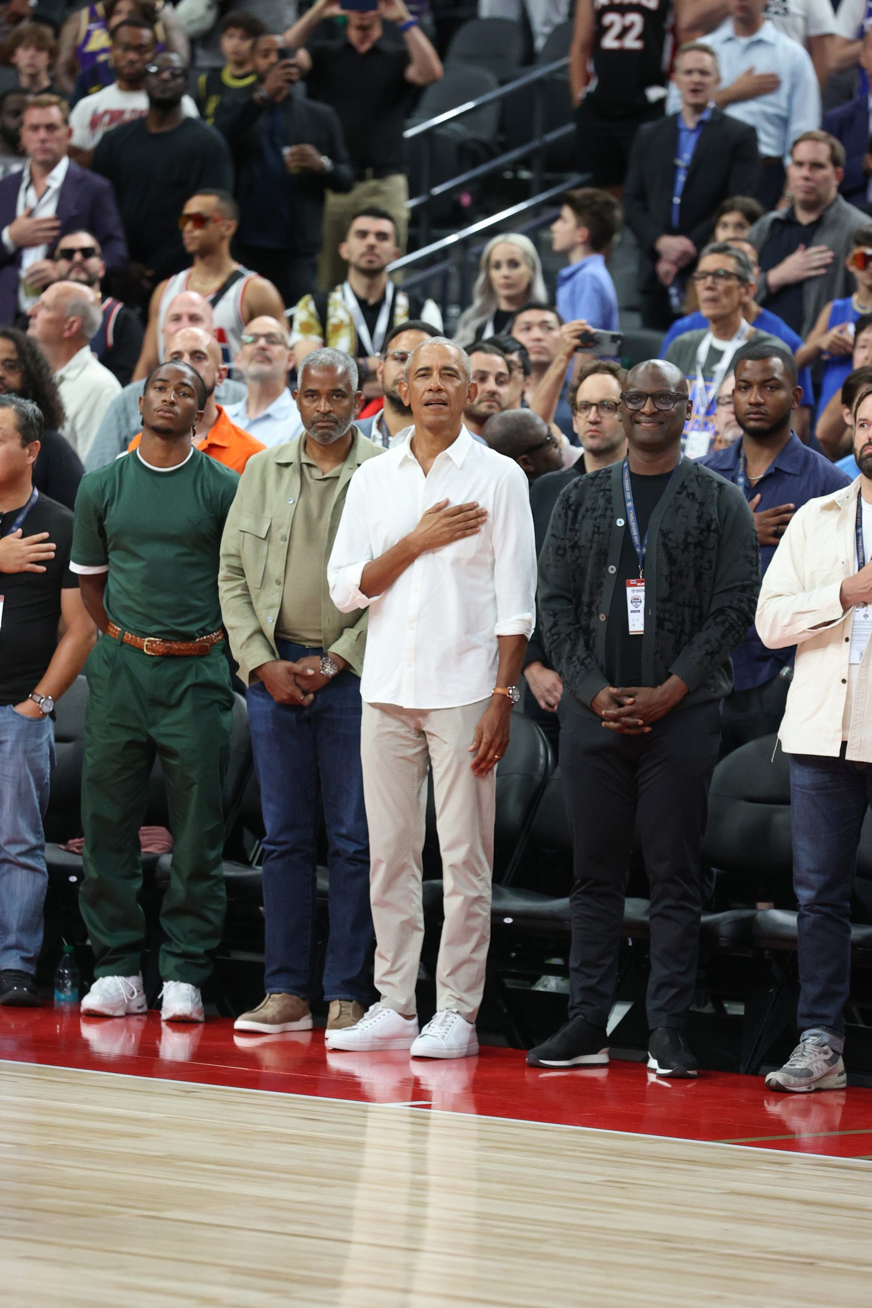 Former US President Barack Obama stands during the national anthem.