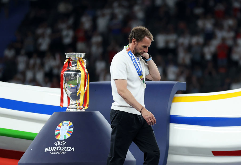 A dejected Gareth Southgate manager walks past the trophy.