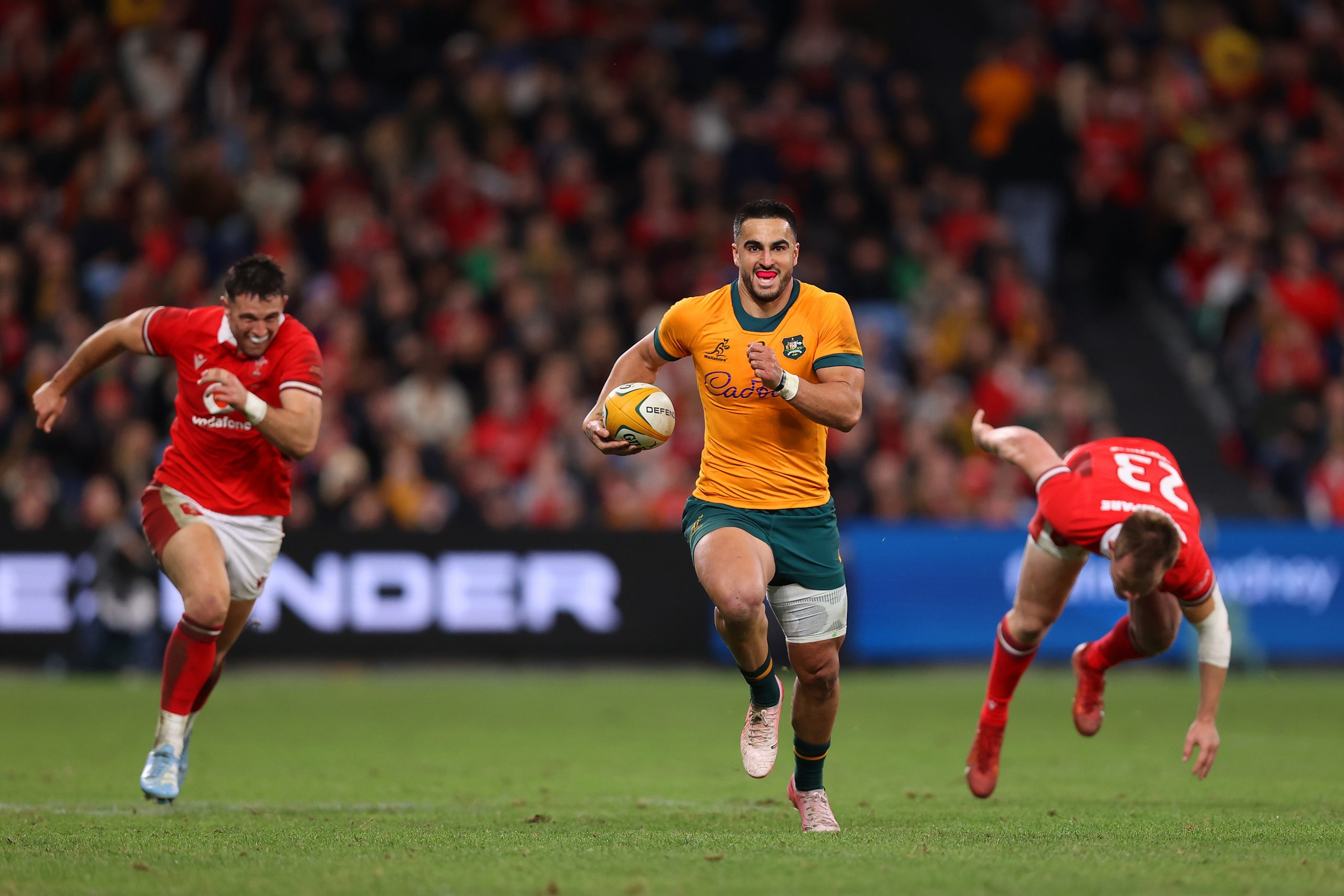 Tom Wright of the Wallabies makes a break before scoring a try.