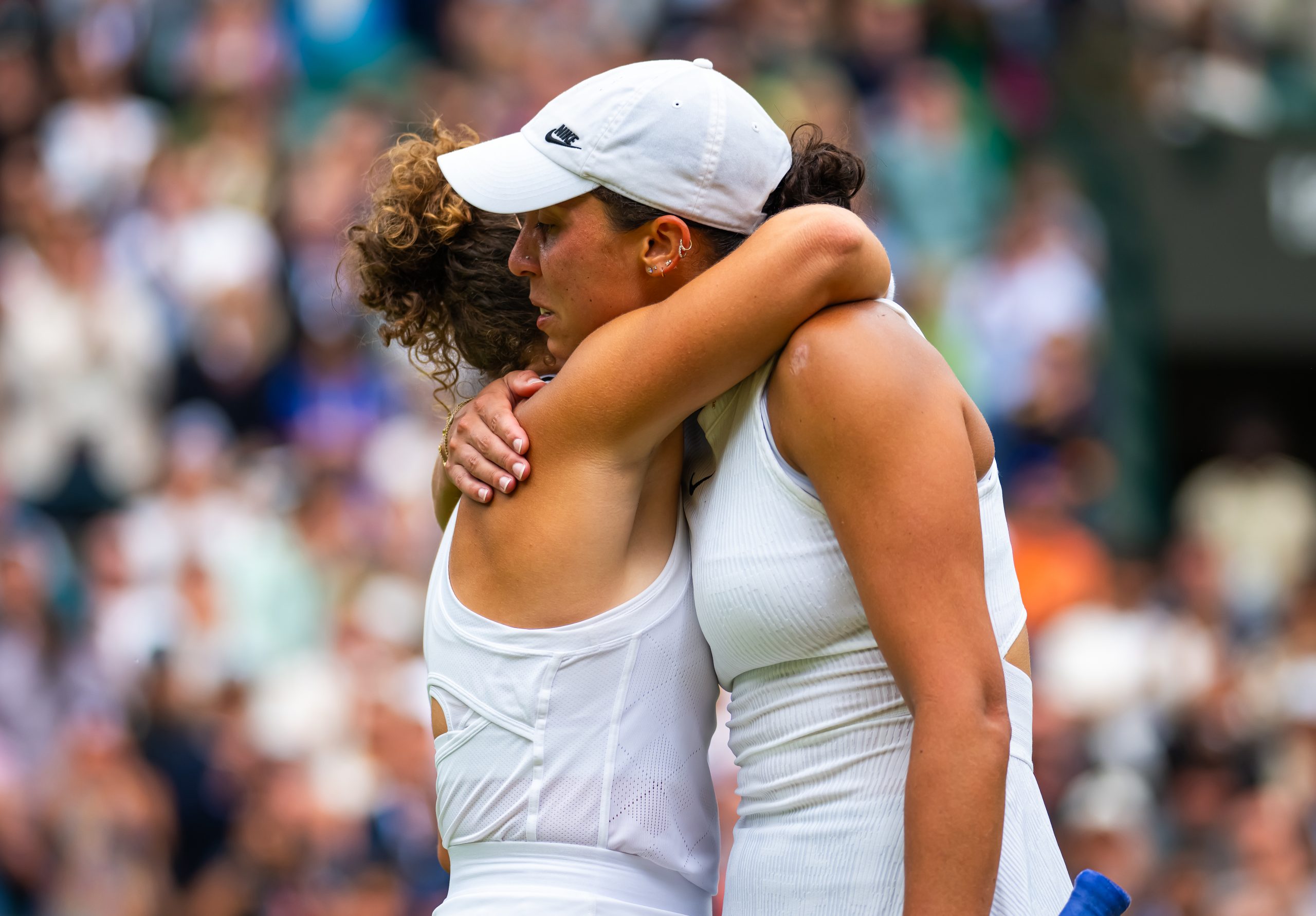 Jasmine Paolini and Madison Keys embrace at the net as Keys is forced to retire with injury from their fourth-round meeting.