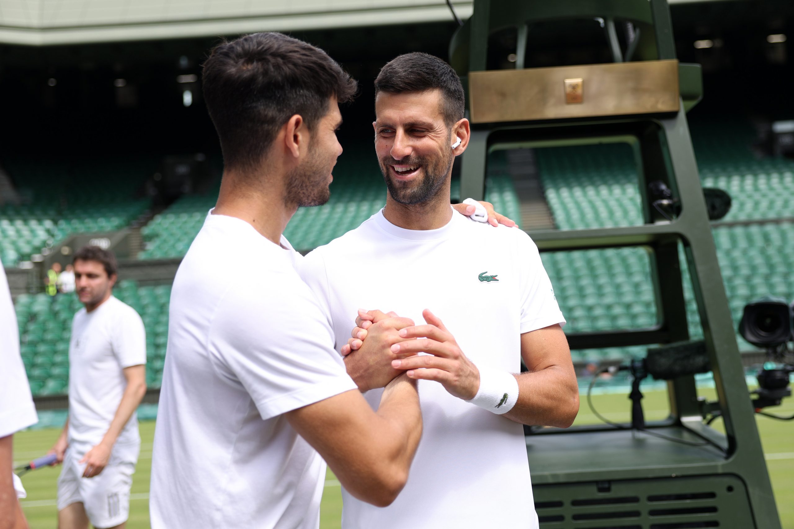 Novak Djokovic of Serbia greets Carlos Alcaraz of Spain during practice on centre court.