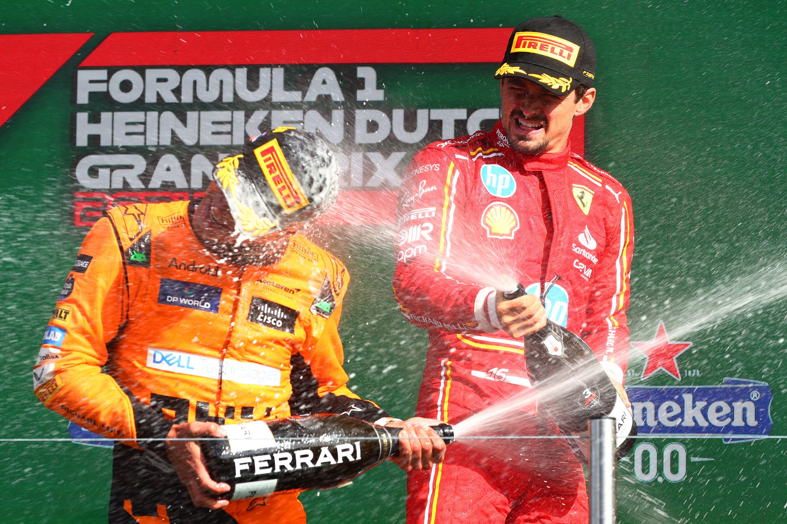 Race winner Lando Norris of Great Britain and McLaren and third placed Charles Leclerc of Monaco and Ferrari celebrate in parc ferme.