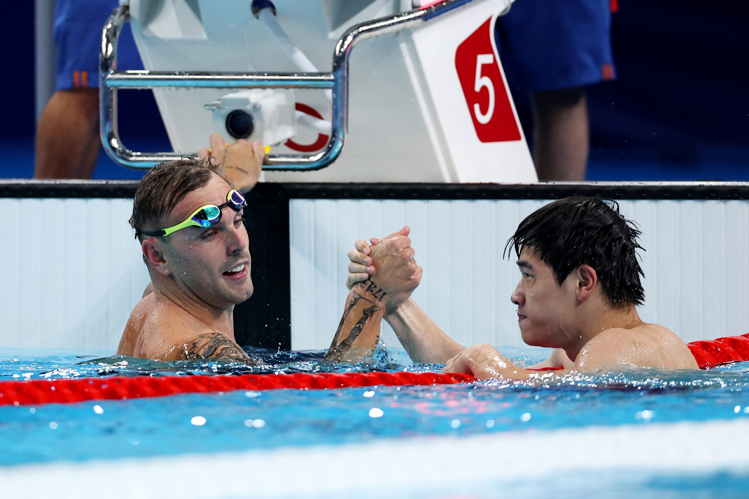 Zhanle Pan of Team People's Republic of China celebrates with Kyle Chalmers of Team Australia after winning gold and silver in the Men's 100m Freestyle Final on day five of the Olympic Games Paris 2024 at Paris La Defense Arena on July 31, 2024 in Nanterre, France. (Photo by Quinn Rooney/Getty Images)