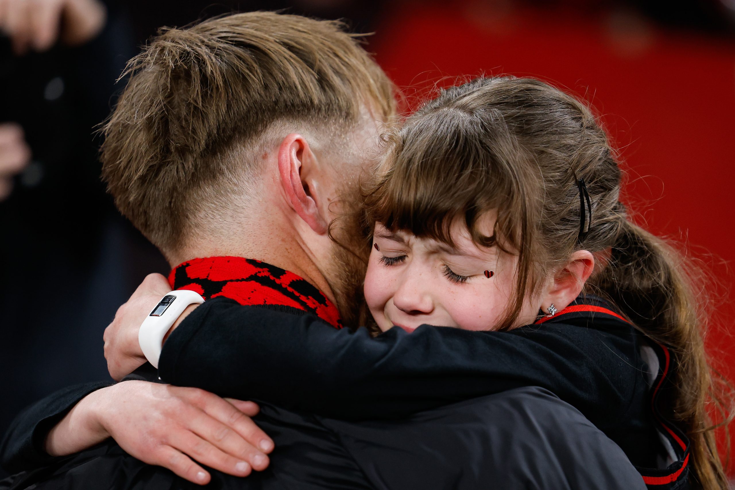 Essendon retiree Dyson Heppell hugs a young fan during their match against Sydney in round 23.