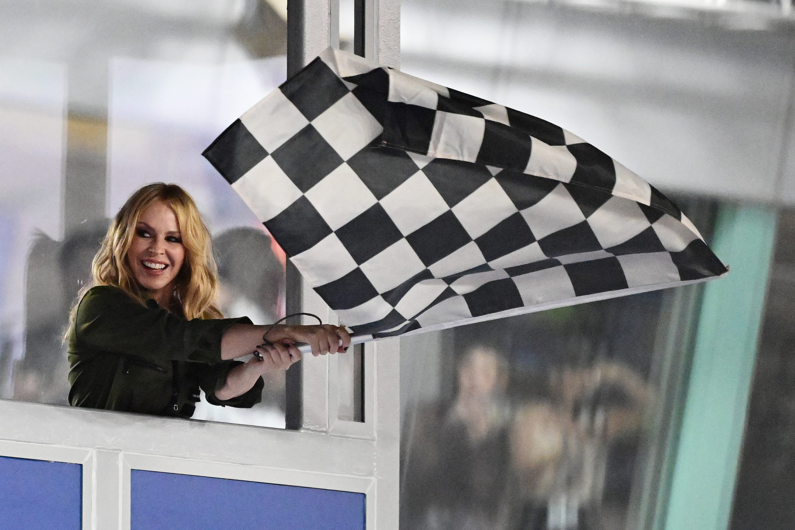 Kylie Minoque waves the chequered flag during the F1 Grand Prix of Singapore at Marina Bay Street Circuit on September 22, 2024 in Singapore, Singapore. (Photo by Pauline Ballet - Formula 1/Formula 1 via Getty Images)