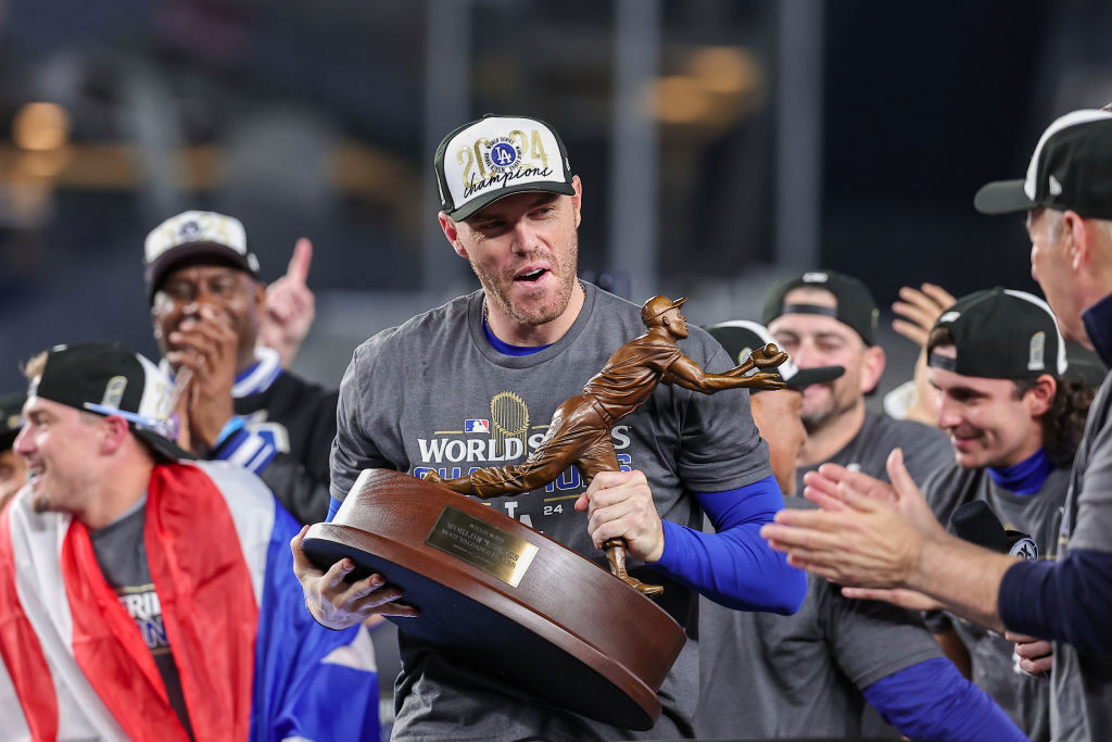 Freddie Freeman #5 of the Los Angeles Dodgers hoists the Willie Mays World Series Most Valuable Player (MVP) Award after defeating the New York Yankees in Game 5 of the 2024 World Series.