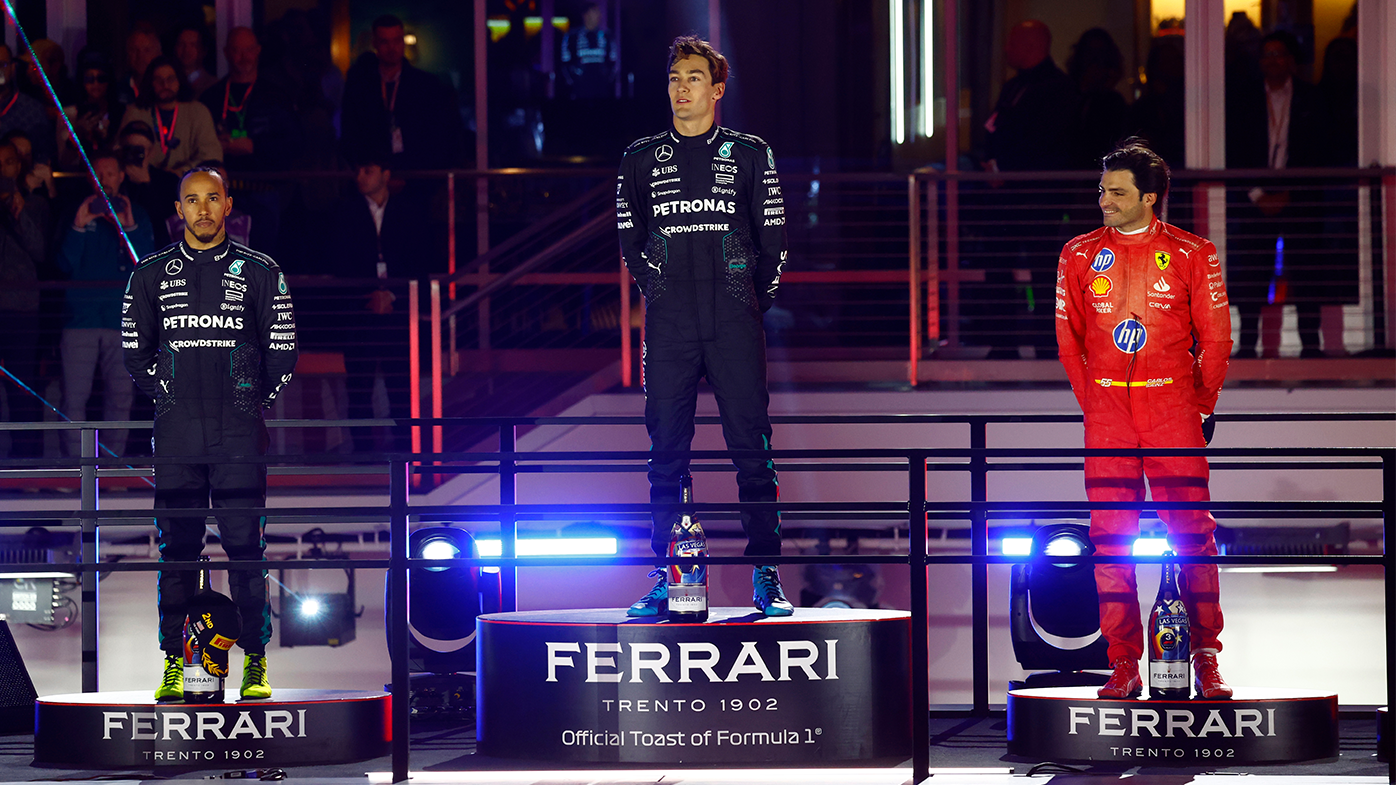 George Russel stands atop the podium alongside Mercedes teammate Lewis Hamilton and Carlos Sainz of Ferrari.