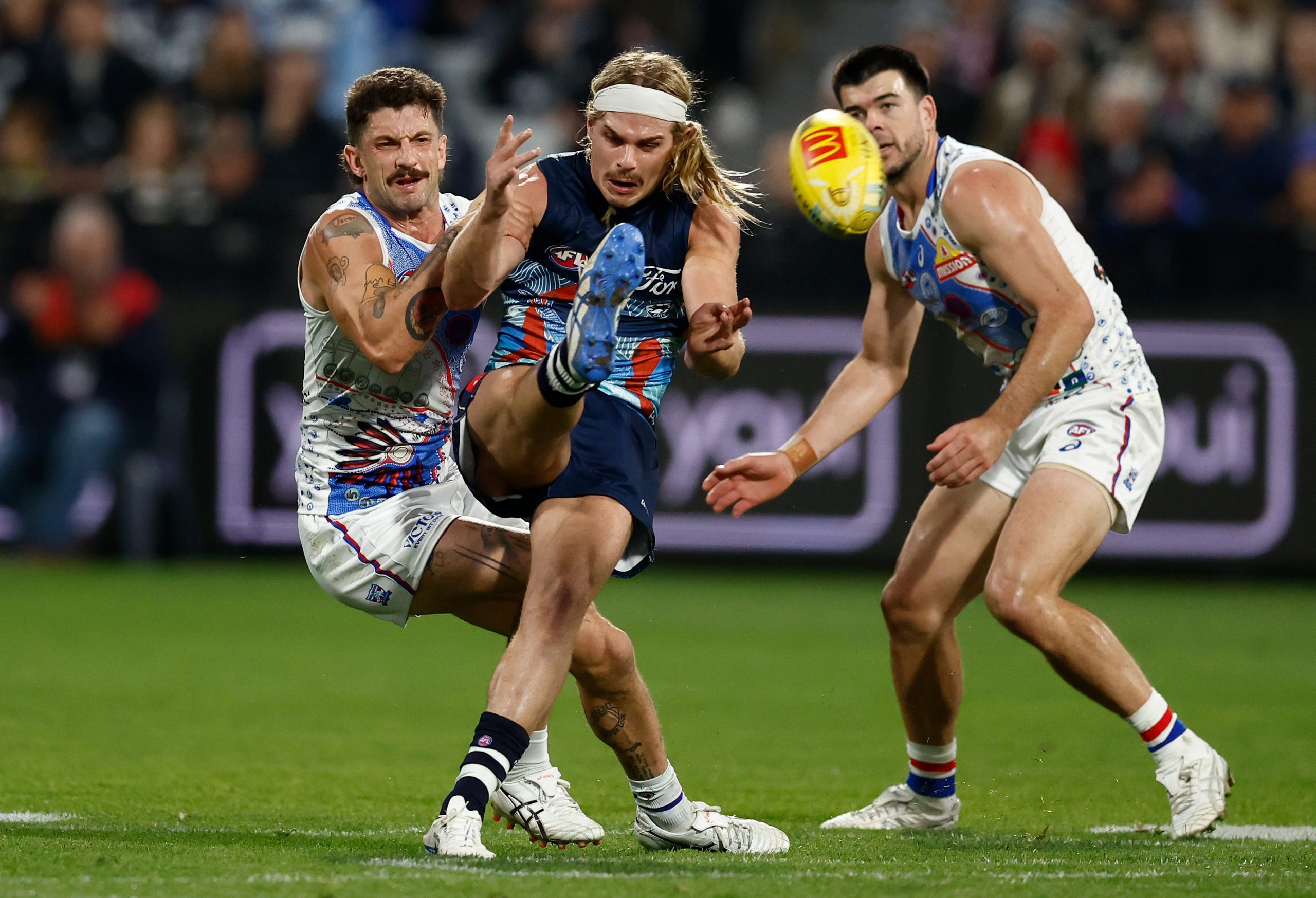 Bailey Smith of the Cats is tackled by Tom Liberatore of the Bulldogs.