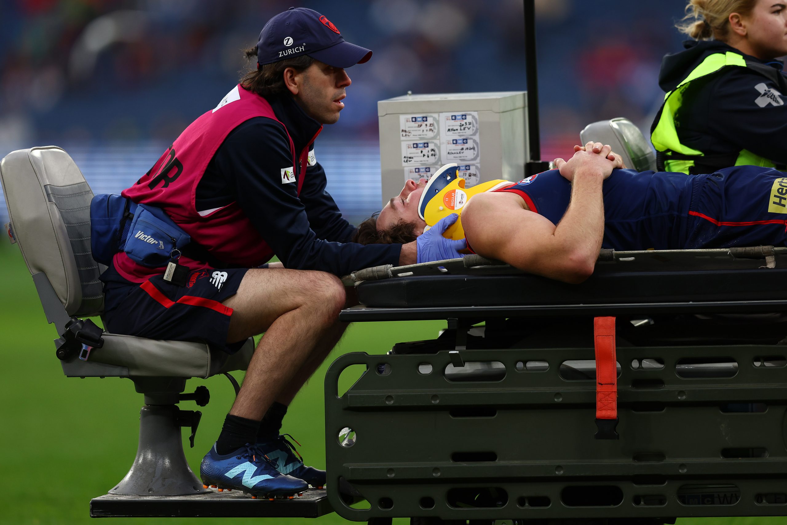 MELBOURNE, AUSTRALIA - JULY 13: Tom Sparrow of the Demons is taken from the field during the round 18 AFL match between Melbourne Demons and North Melbourne Kangaroos at Melbourne Cricket Ground on July 13, 2025 in Melbourne, Australia. (Photo by Graham Denholm/Getty Images)