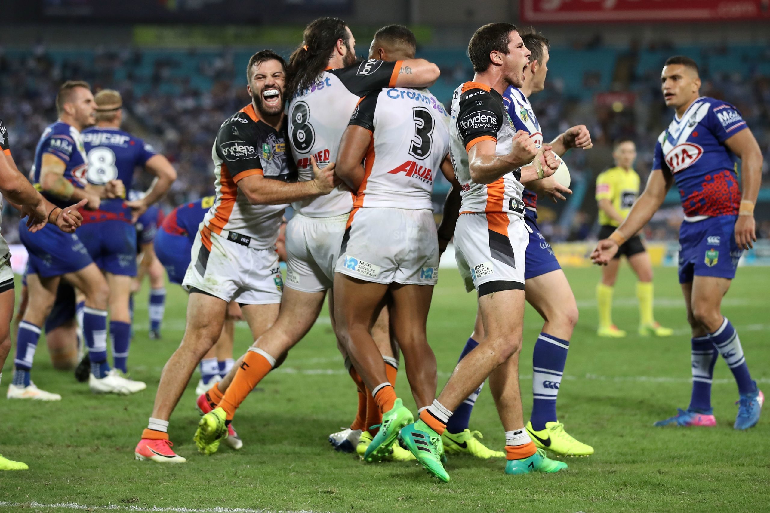 James Tedesco, Aaron Woods and Mitchell Moses celebrating a Wests Tigers victory in 2017.
