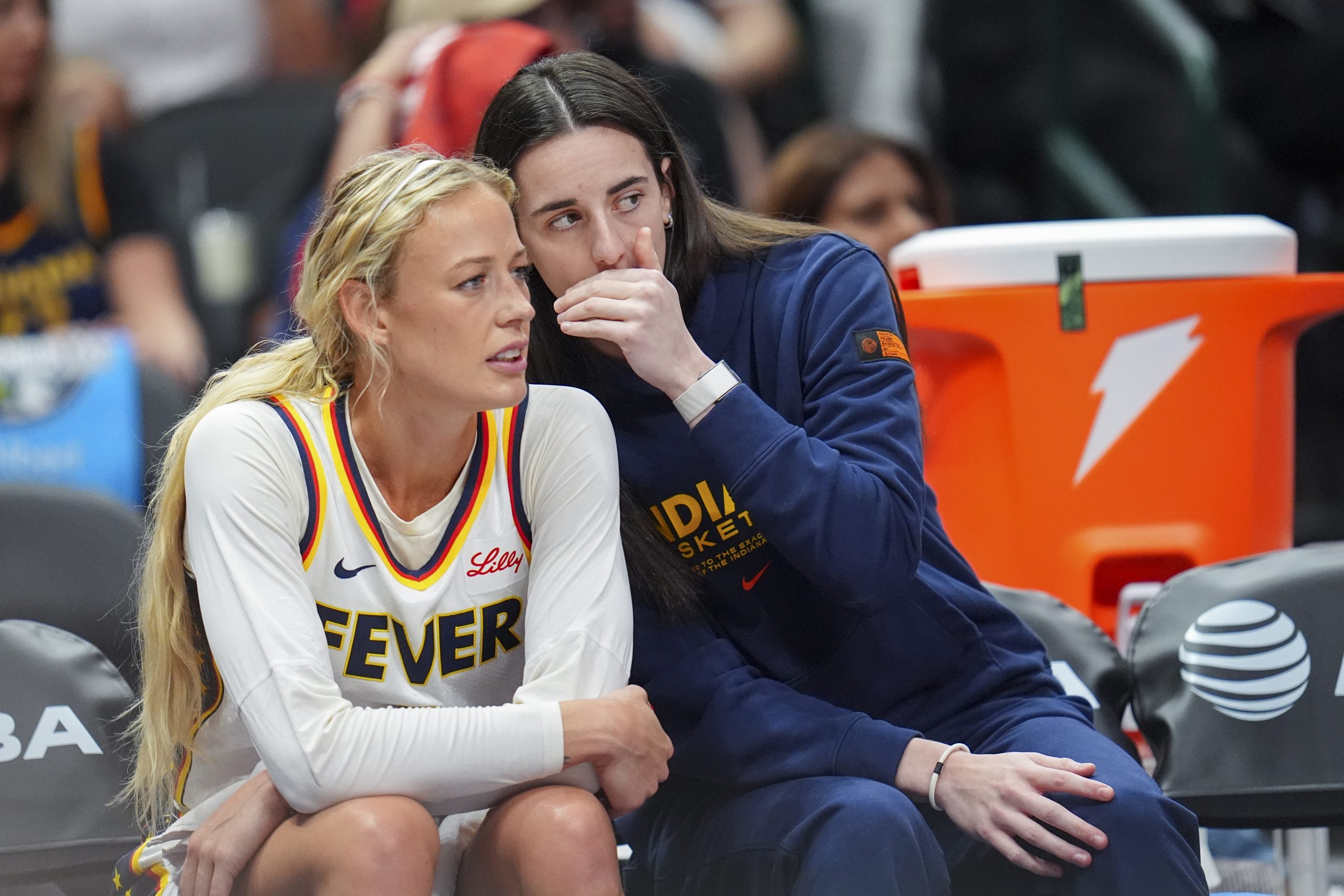 Indiana Fever guard Caitlin Clark, right, talks with Sophie Cunningham during a WNBA game.