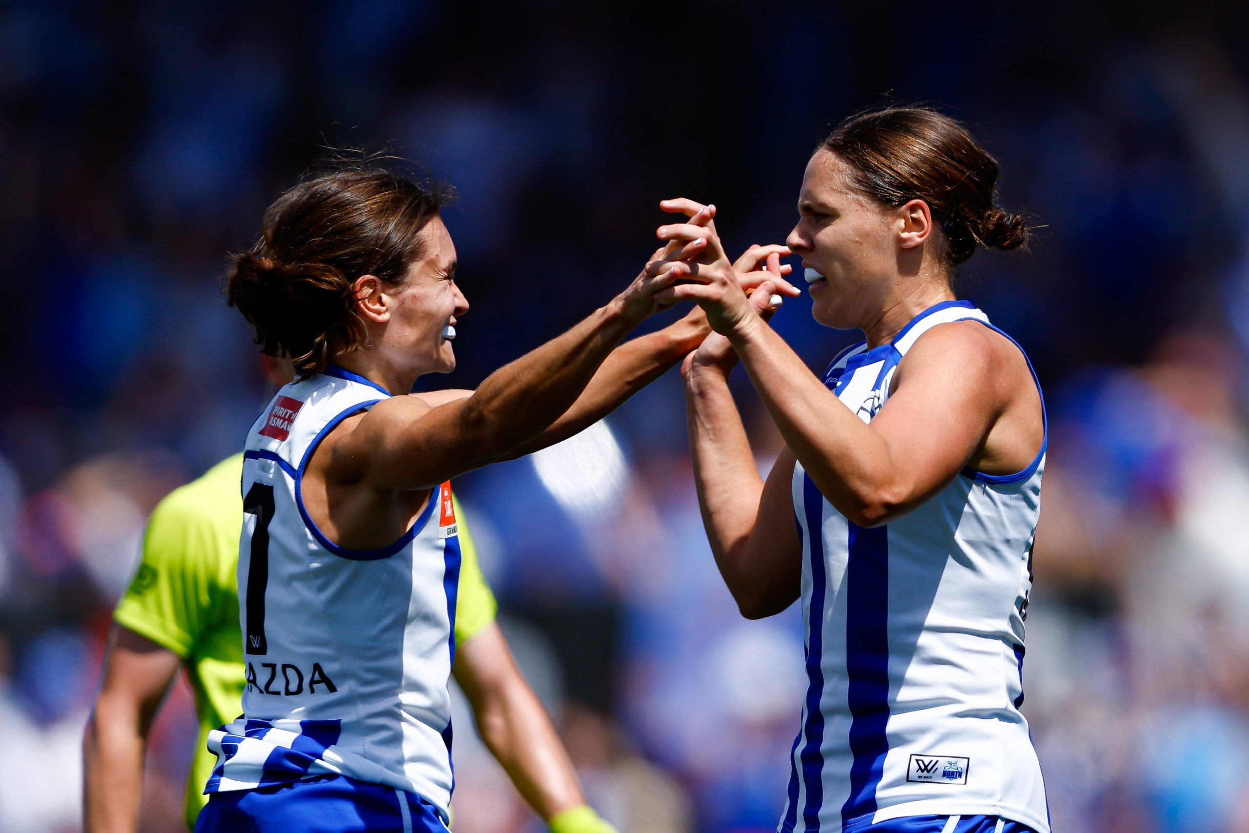 Jasmine Garner celebrates a goal with Kangaroos teammate Ash Riddell.
