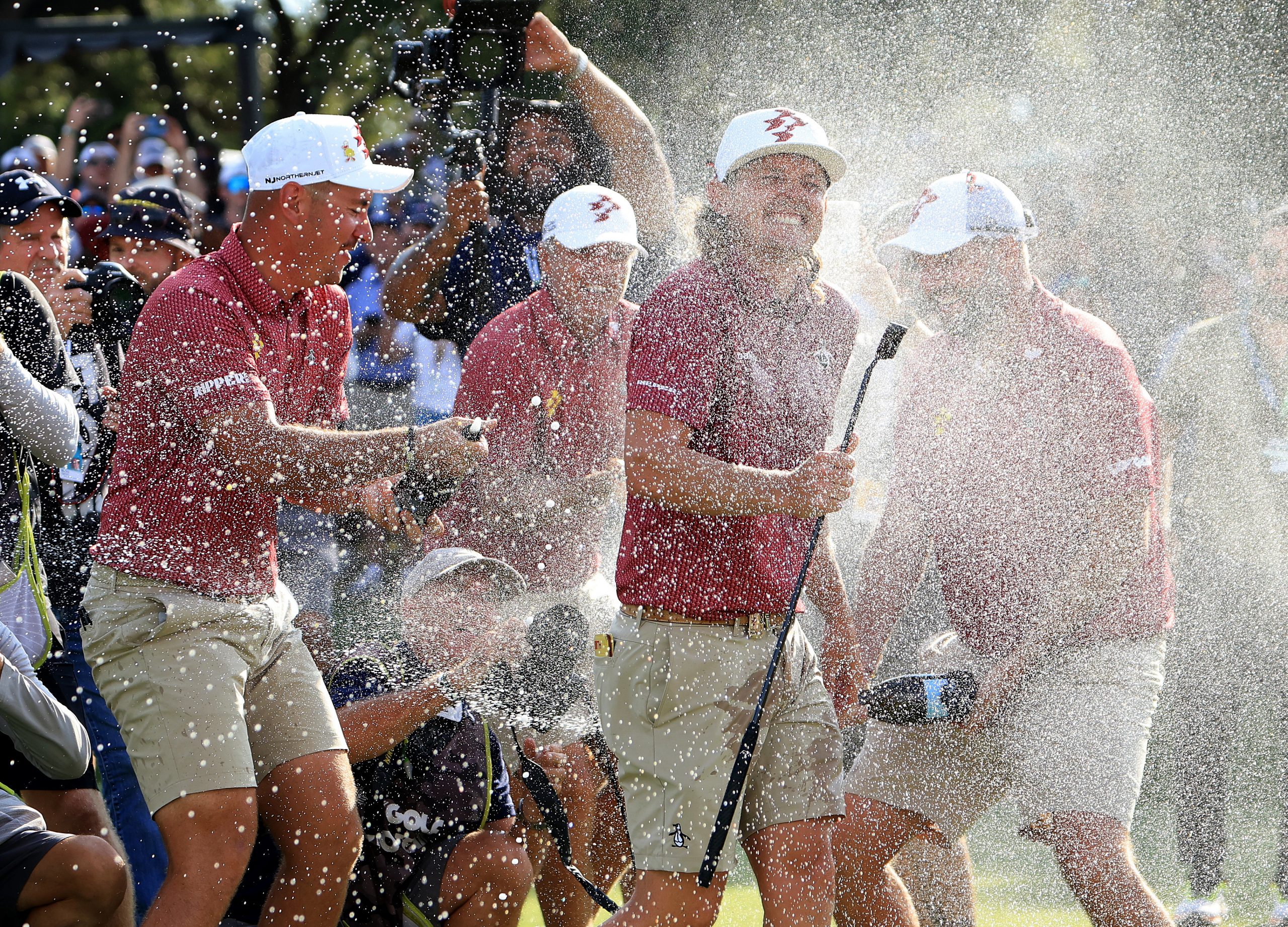 DALLAS, TEXAS - SEPTEMBER 22: Cameron Smith of Australia and The Ripper GC team is soaked with champagne by his teammates Lucas Herbert, Marc Leishman and Matt Jones after holing teh winning putt on the 18th green  during the individual team stroke-play finals on day three of the LIV Golf Team Championship Dallas at Maridoe Golf Club on September 22, 2024 in Dallas, Texas. (Photo by David Cannon/Getty Images)