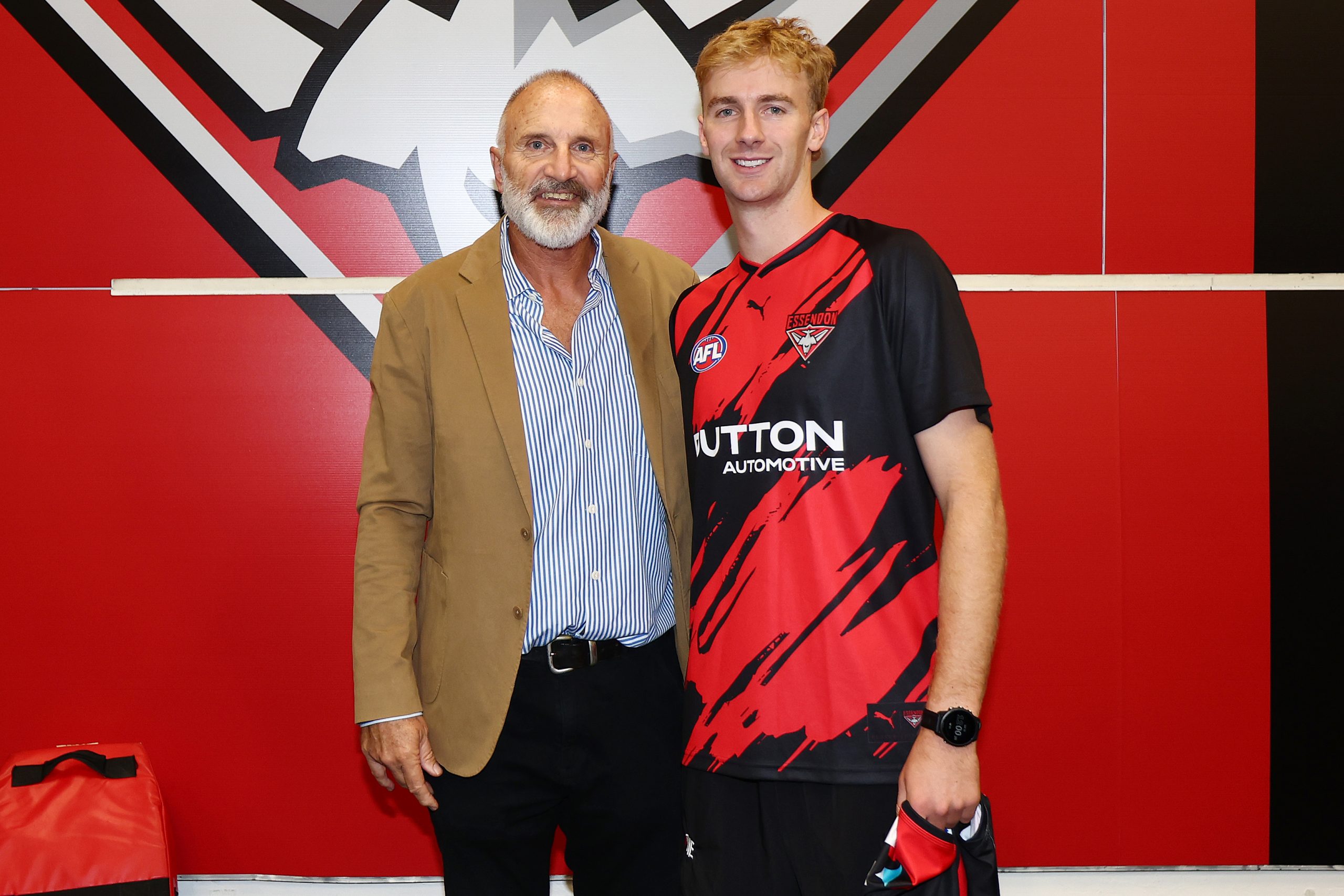 Tim Watson poses with Tom Edwards following an Essendon guernsey presentation in 2025.