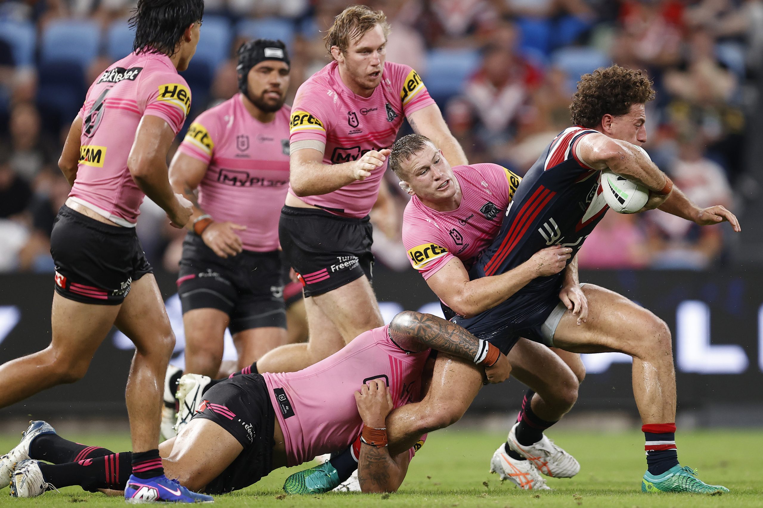 Mark Nawaqanitawase of the Roosters is tackled by Panthers players.