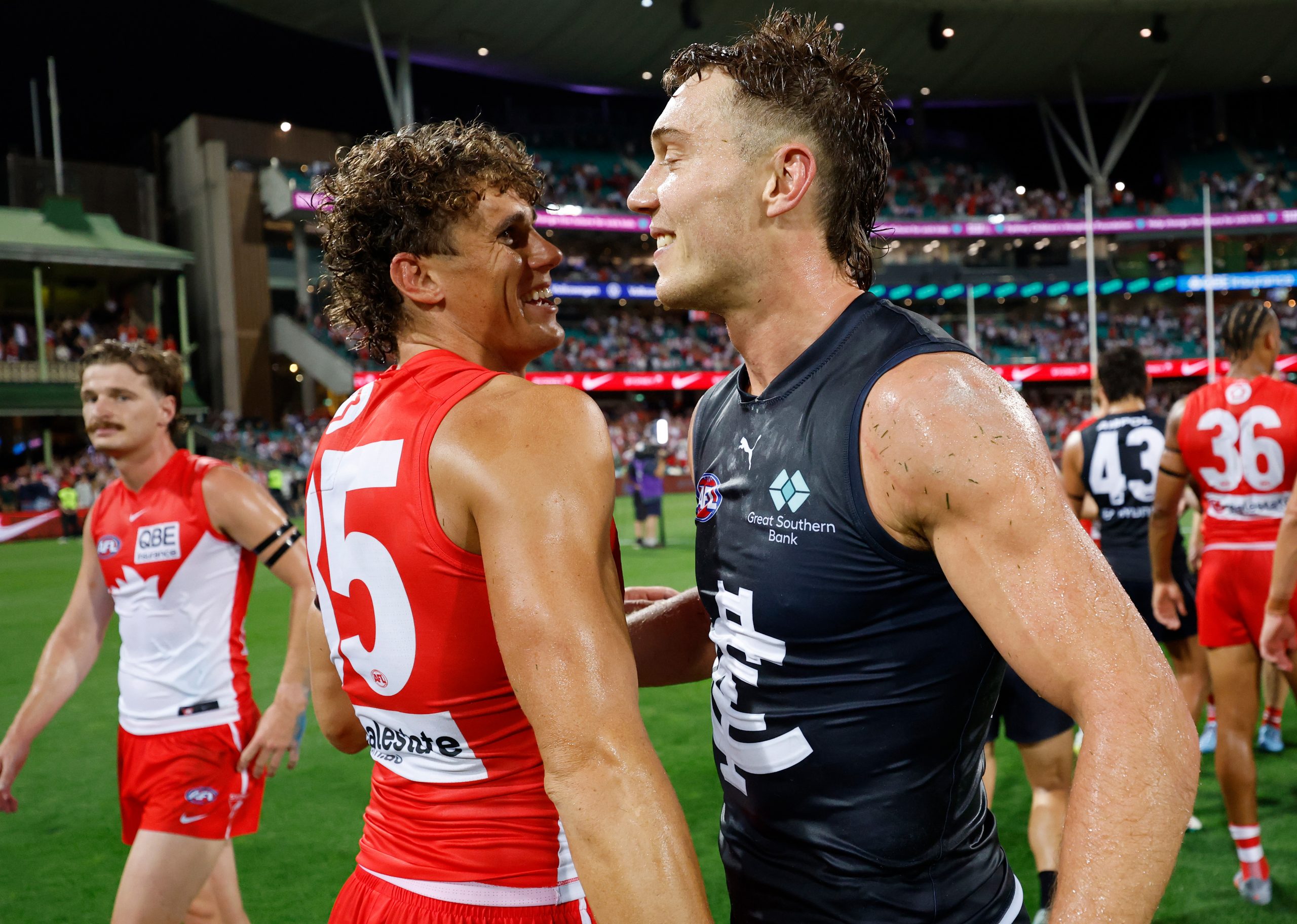 Charlie Curnow of the Swans and Patrick Cripps of the Blues embrace.