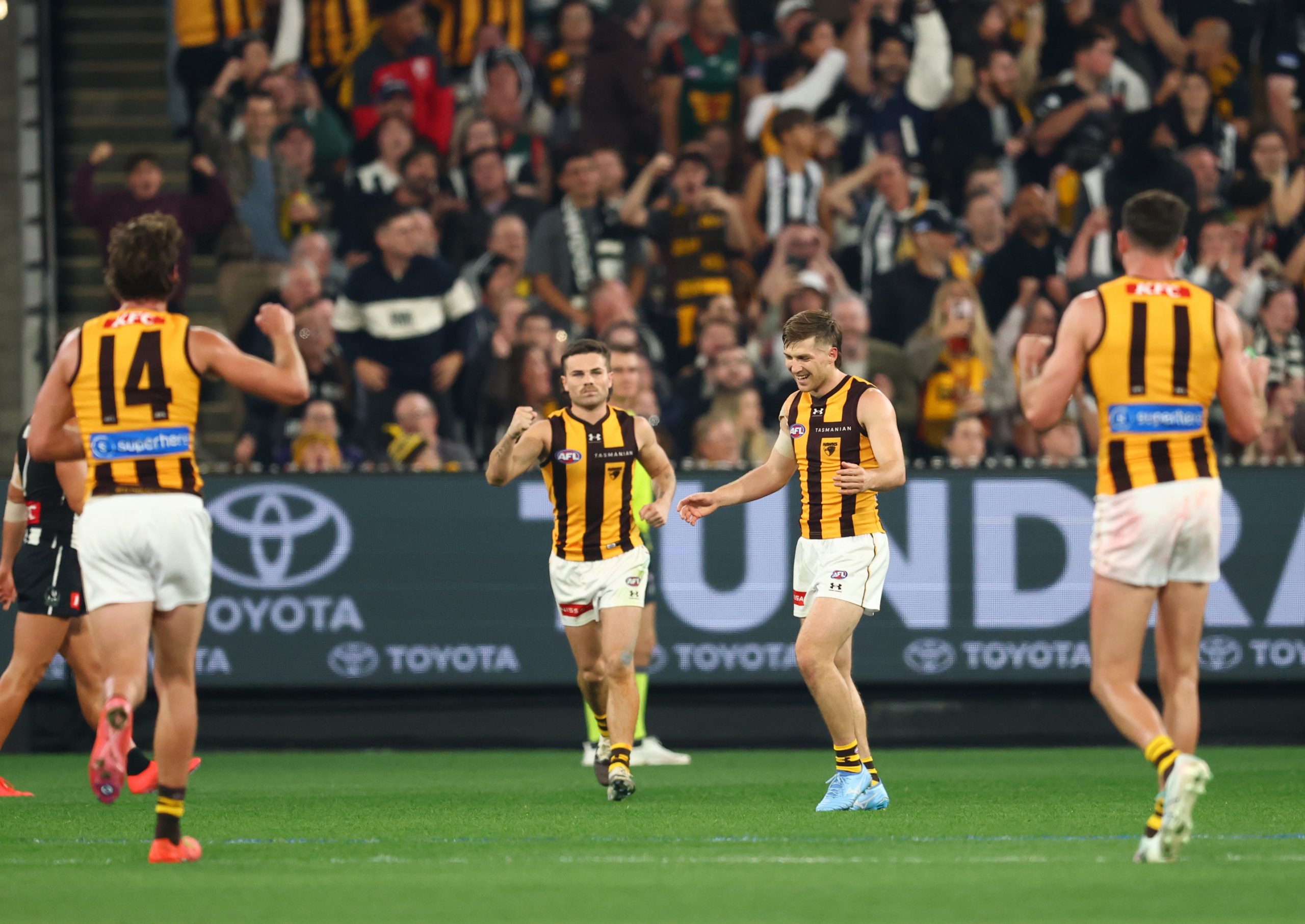 MELBOURNE, AUSTRALIA - APRIL 30: Dylan Moore of the Hawks celebrates with team mates after he kicked a goal on the siren for the match to end in a draw during the round eight AFL match between Collingwood Magpies and Hawthorn Hawks at Melbourne Cricket Ground, on April 30, 2026, in Melbourne, Australia. (Photo by Robert Cianflone/Getty Images)