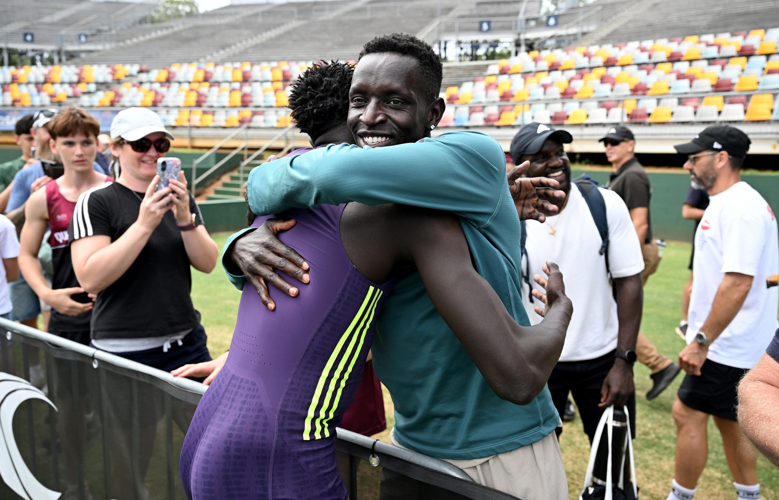 BRISBANE, AUSTRALIA - MARCH 14: Gout Gout embraces with Peter Bol after winning the final of the Men's U20 100m event during the 2026 Queensland Athletics Championships at Queensland Sport and Athletics Centre on March 14, 2026 in Brisbane, Australia. (Photo by Bradley Kanaris/Getty Images)
