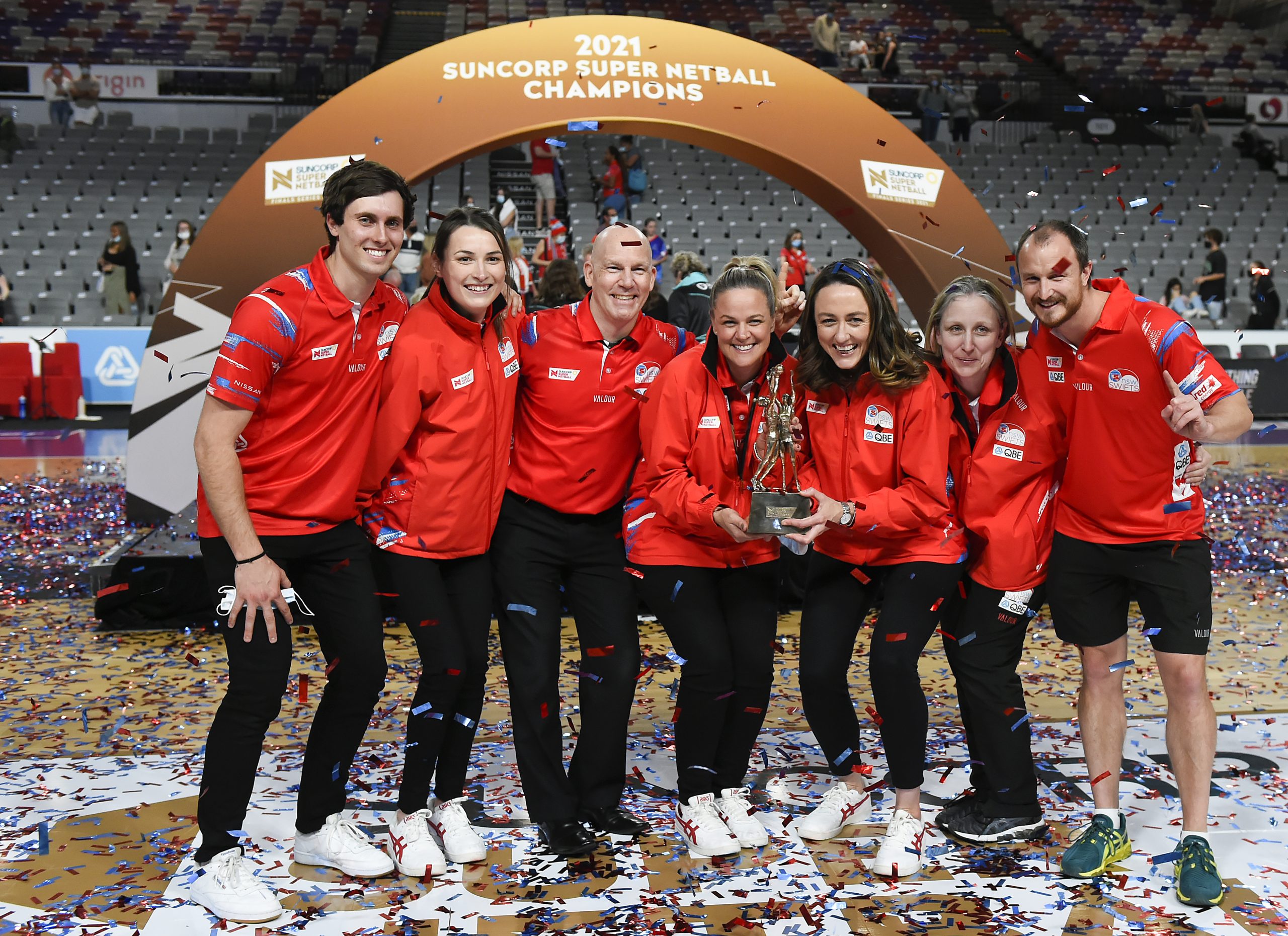 BRISBANE, AUSTRALIA - AUGUST 28: NSW Swifts head coach Briony Akle (centre) and the rest of the Swifts staff pose with the trophy after their victory with the during the 2021 Super Netball Grand Final match between Sydney Swifts and GWS Giants at Nissan Arena, on August 28, 2021, in Brisbane, Australia. (Photo by Albert Perez/Getty Images)